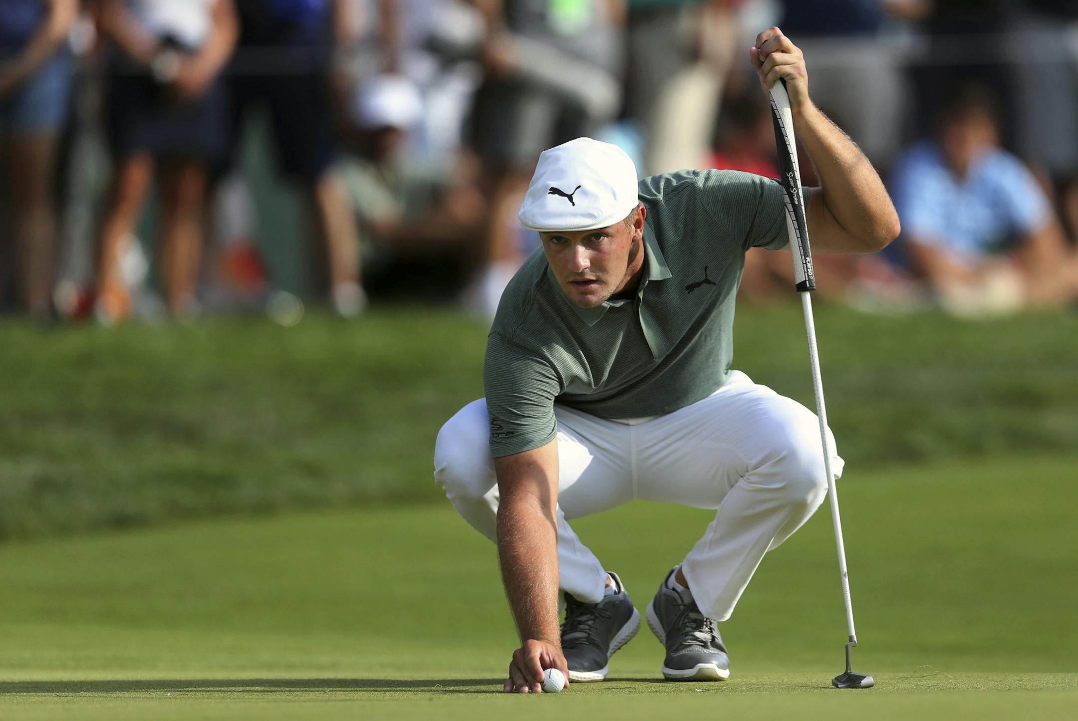 Bryson DeChambeau eyes his putt as he places his ball on the green at the 18th hole during the third round of the Northern Trust golf tournament, Saturday, Aug. 25, 2018, in Paramus, N.J. (AP Photo/Mel Evans)