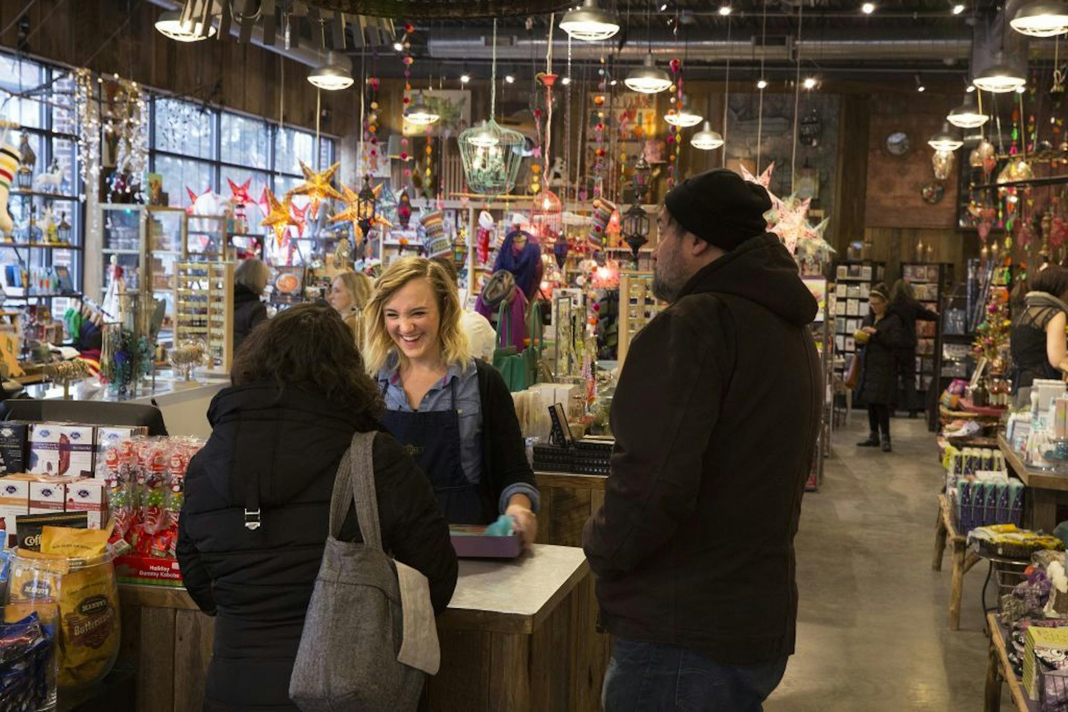 Hannah Nolte helps customers at the register at Patina in Minneapolis on Friday, December 5, 2014. Nolte has been working for Patina for three months.