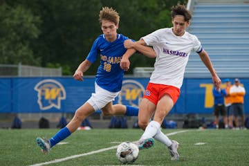 Wayzata's Miles Redmond (18) and Washburn's Nels Mortenson (8) get tied up while battling for a loose ball at Wayzata High School in Plymouth, Minn., 