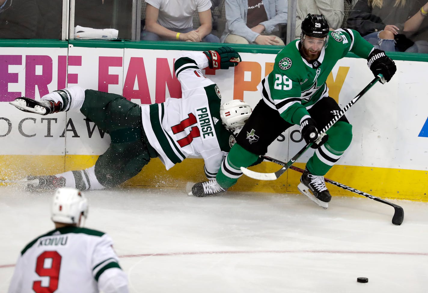 Minnesota Wild center Mikko Koivu (9) watches left wing Zach Parise (11) slam into the boards as Dallas Stars defenseman Greg Pateryn (29) comes away with the loose puck in the third period of an NHL hockey game in Dallas, Saturday, March 31, 2018. (AP Photo/Tony Gutierrez)