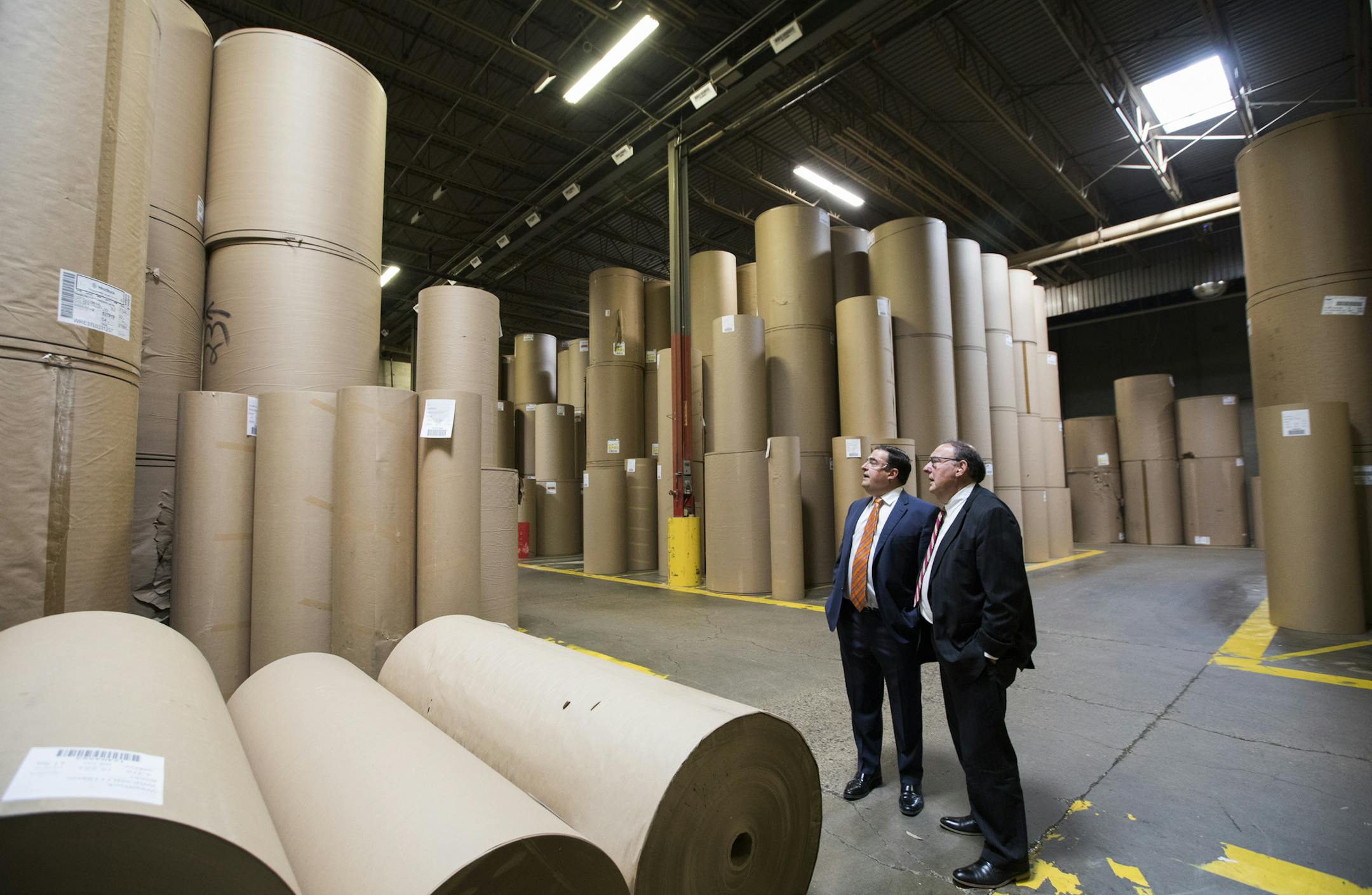 Mike Fiterman, CEO of Liberty Carton Co., right, and his son Jack Fiterman, a vice president, stand among the rolls of paper that will be made into corrugated cardboard. ] LEILA NAVIDI ï leila.navidi@startribune.com BACKGROUND INFORMATION: Tour of Liberty Carton Company in Golden Valley on Friday, April 6, 2018.