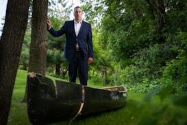 Erik Grams stands with his damaged canoe June 13 at his home in Ham Lake. Grams was part of a fishing group that went over Curtain Falls in the BWCAW 
