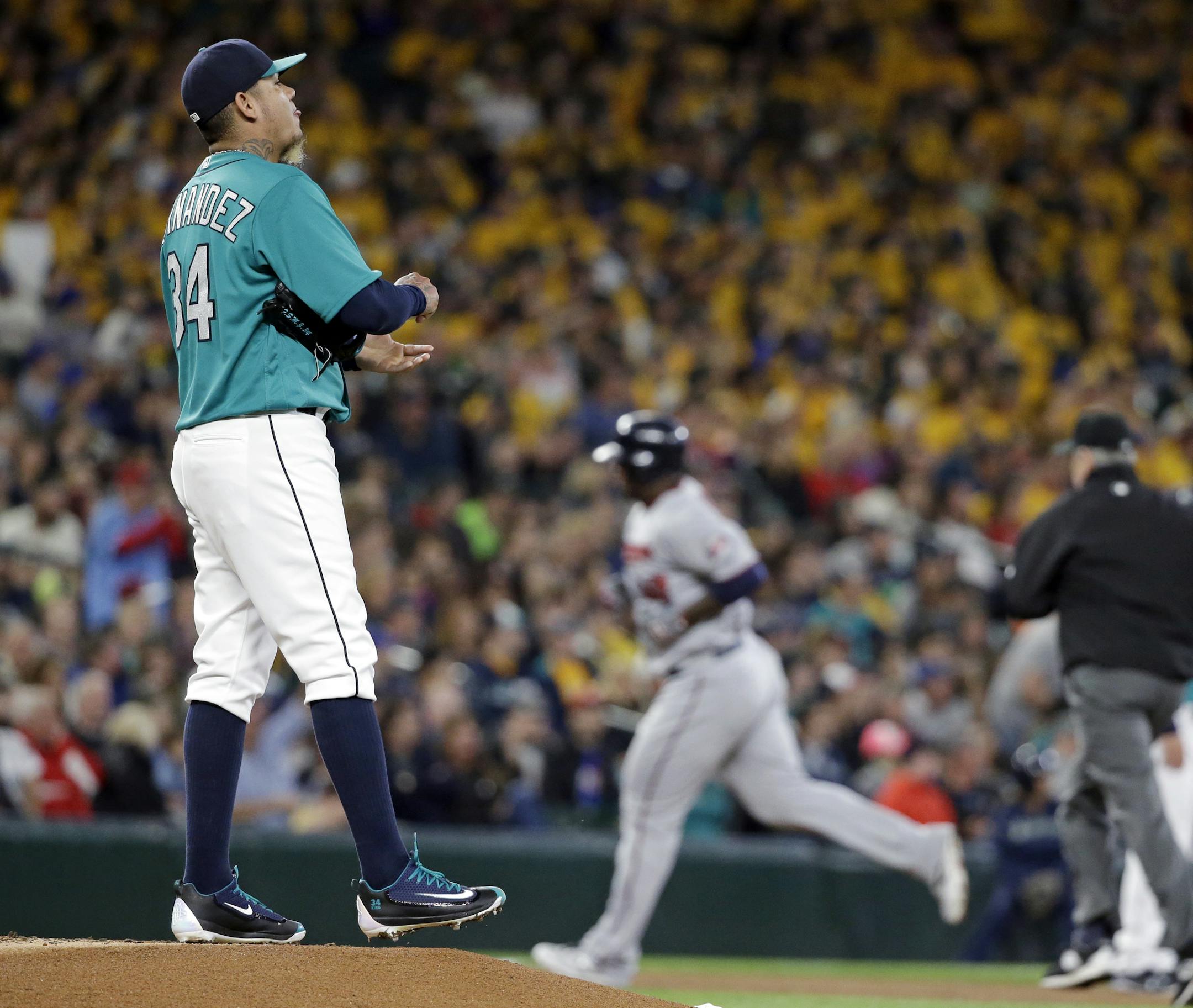 Seattle Mariners starting pitcher Felix Hernandez, left, waits as Minnesota Twins' Miguel Sano rounds the bases on a home run during the second inning of a baseball game Friday, May 27, 2016, in Seattle. (AP Photo/Elaine Thompson)
