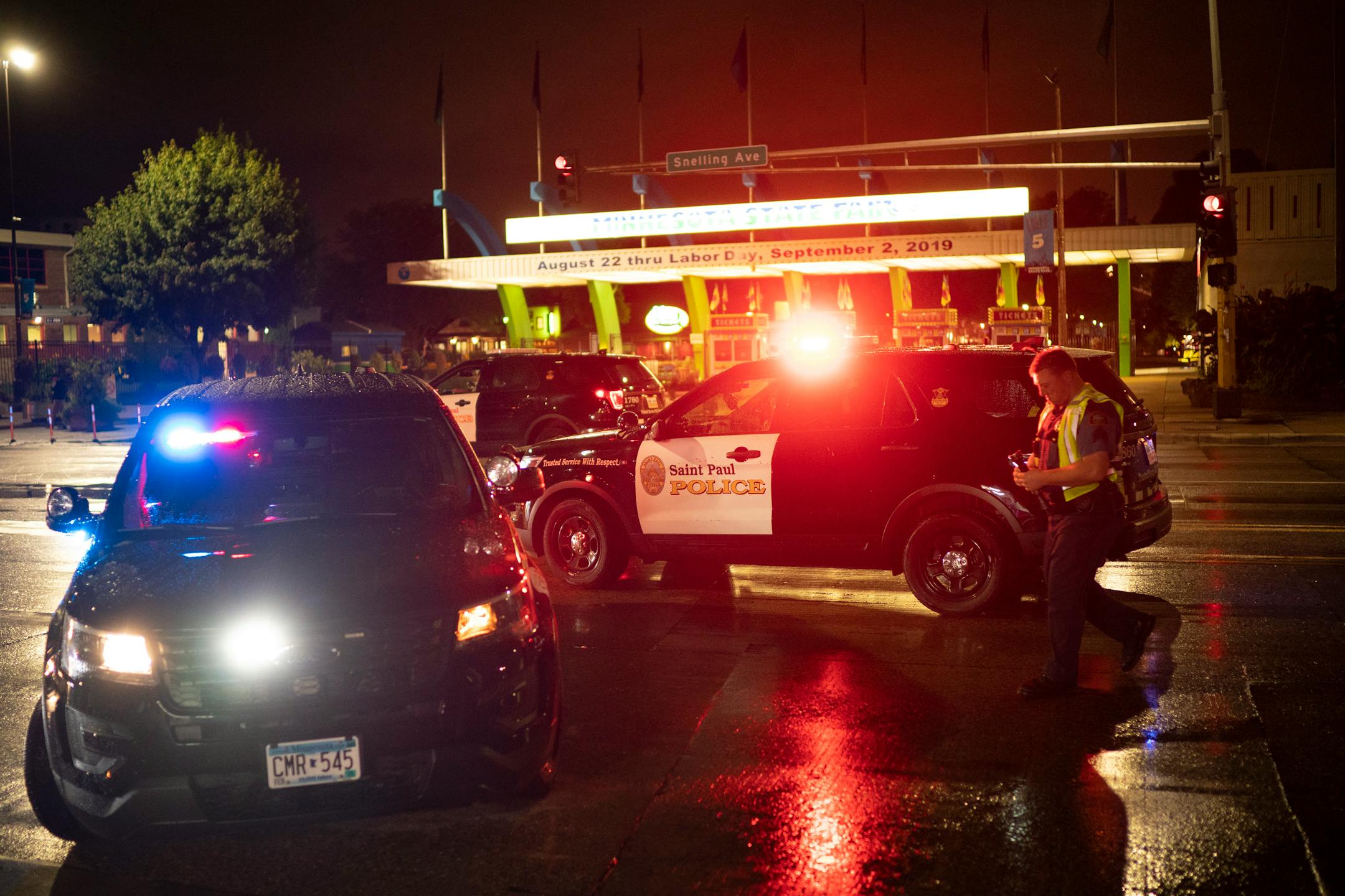 Police vehicles near the main entrance to the Minnesota State Fairgrounds late Monday. Three people were wounded by gunfire just as the fair was wrapping up.