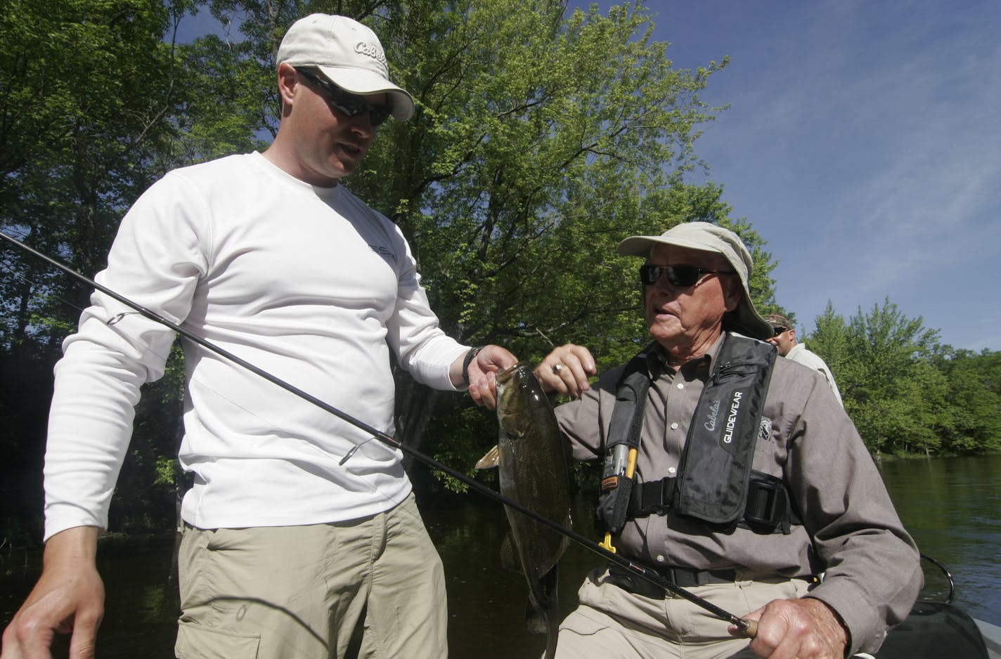 Nate Foster (left), 35, of St. Cloud, a veteran of the wars in Afganistan and Iraq, and his grandfather, Swede Anderson, 82, of Rochester, a veteran of the Korean War, holds a smallmouth bass Anderson caught during the Trolling for the Troops event Friday at Camp Ripley.