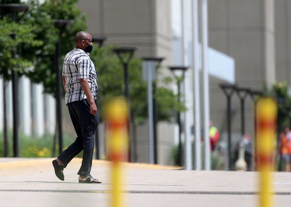 A worker is seen outside Amazon.com Inc.'s giant fulfillment center Tuesday in Shakopee, where at least 88 of its approximately 1,000 workers testing 