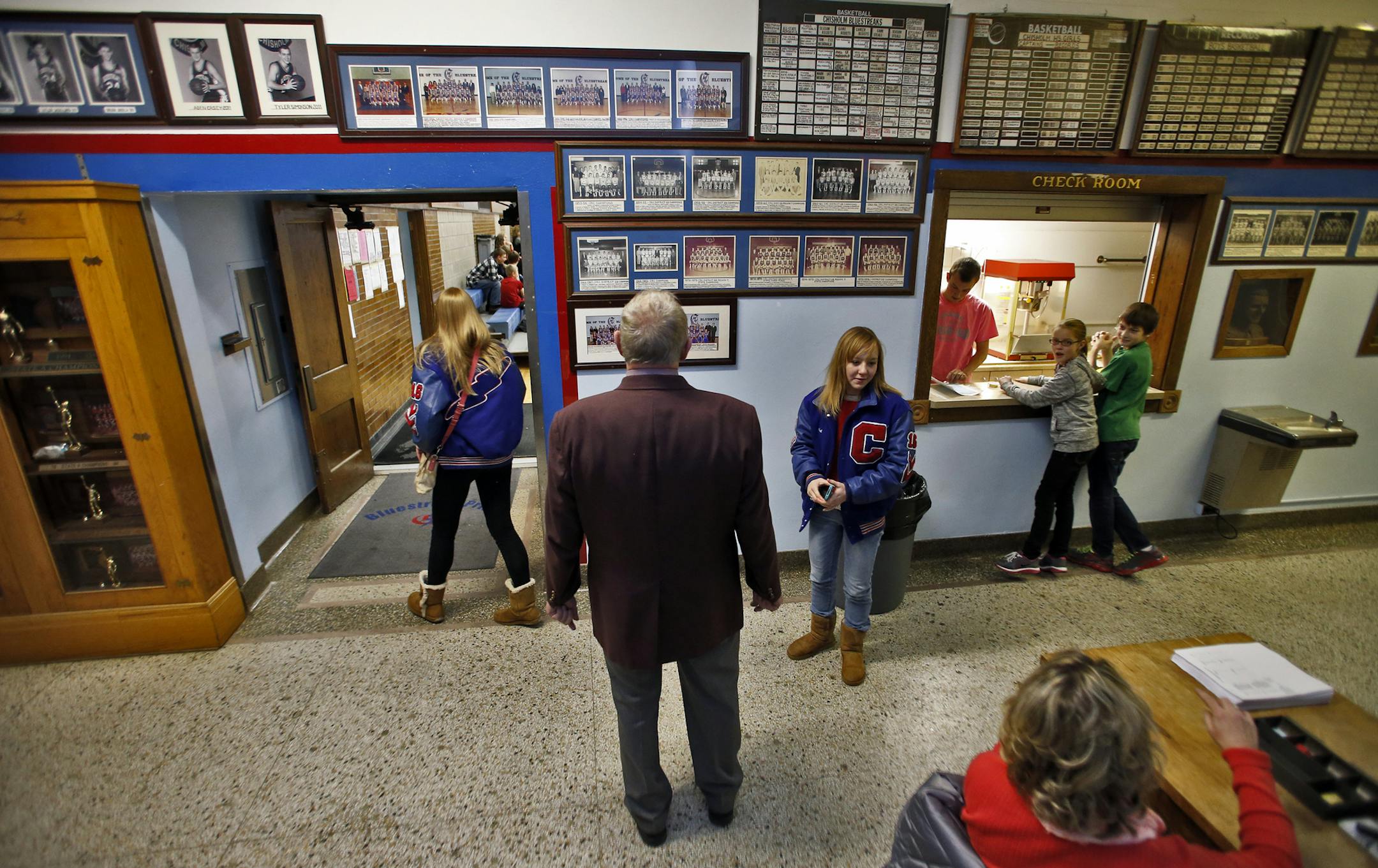 In this photo from 2013, Chisholm basketball coach Bob McDonald stopped to look at some of the basketball trophies on display in the Chisholm High hallways.