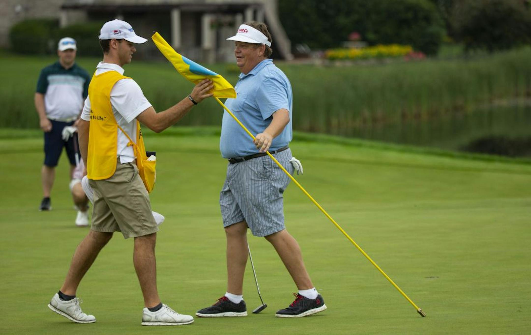Luke Nelson (left) takes the pin on the 16th hole from PGA Tour veteran Tim Herron. ALEX KORMANN ¥ alex.kormann@startribune.com Caddie U is a local non-profit that trains and places primarily teenage caddies for work at Twin Cities golf clubs. The program is supported by PGA Tour veteran Tim Herron. Jacob Roy had to work two jobs to support himself the last few years but through caddying and Caddie U, was able to pull himself up and receive a partial scholarship to attend the University of Minne