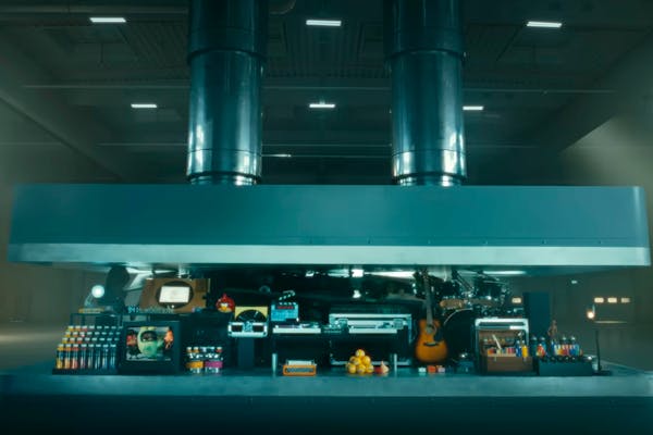 In this image taken from an Apple advertisement for which the company has since apologized, a hydraulic press crushes an array of creative instruments