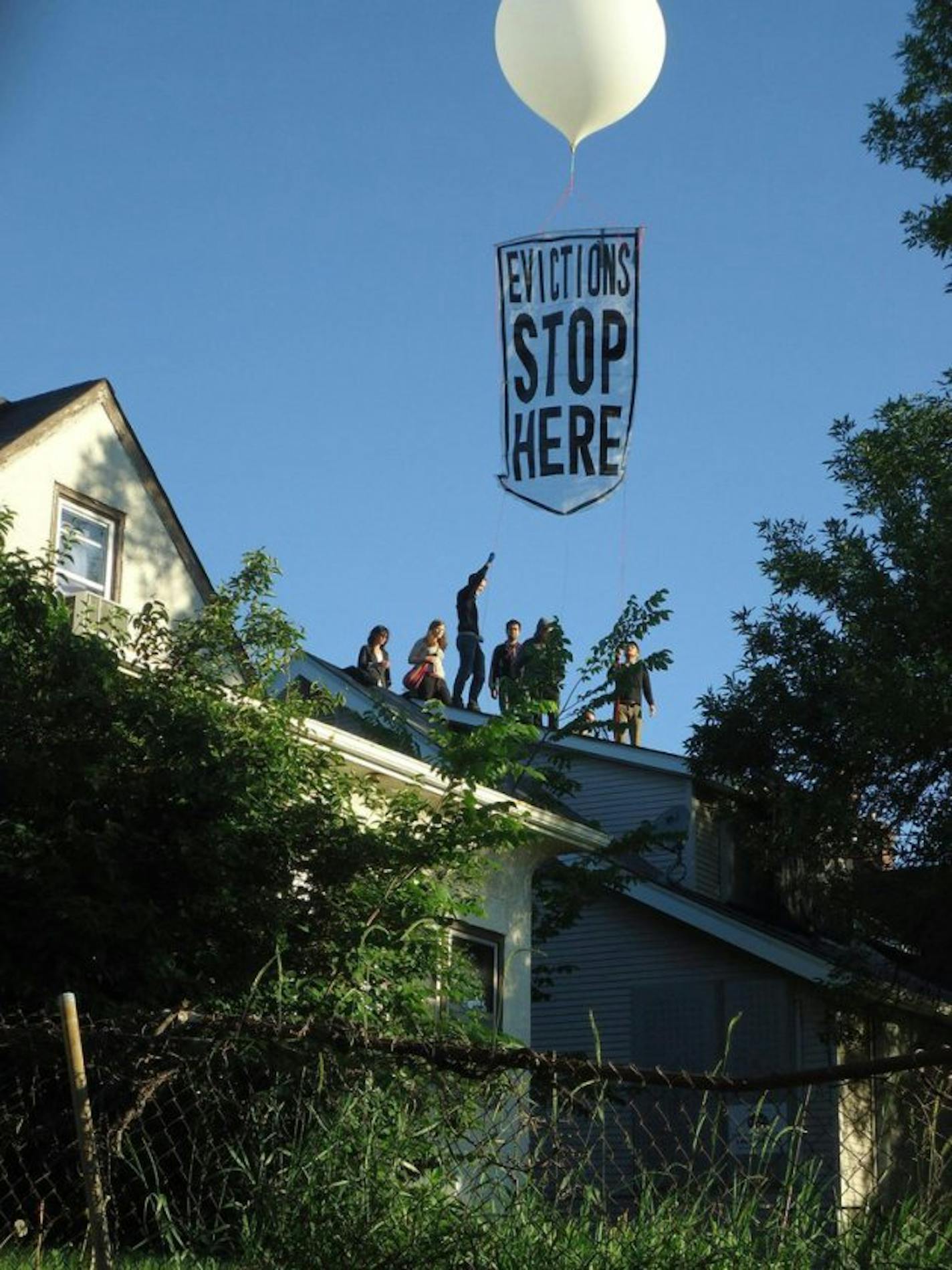 Protesters deploy balloon banner over Cruz house. Photo courtesy of Occupy Homes MN