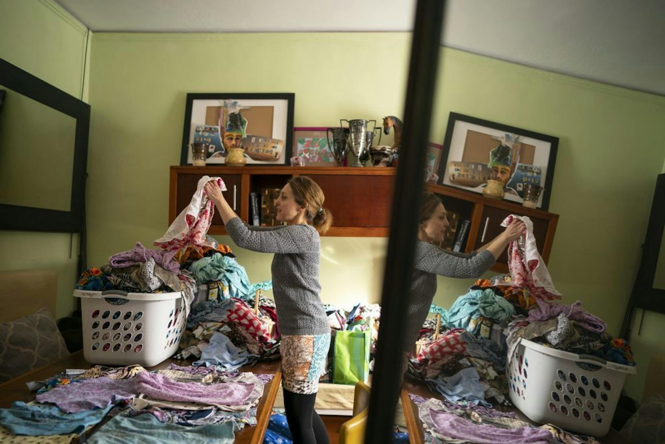 Jane Fischer sorted through fabric scraps looking for the right combination to make one of her signature dresses. She was working in her two room apartment in the Main House of the Monterey Community.