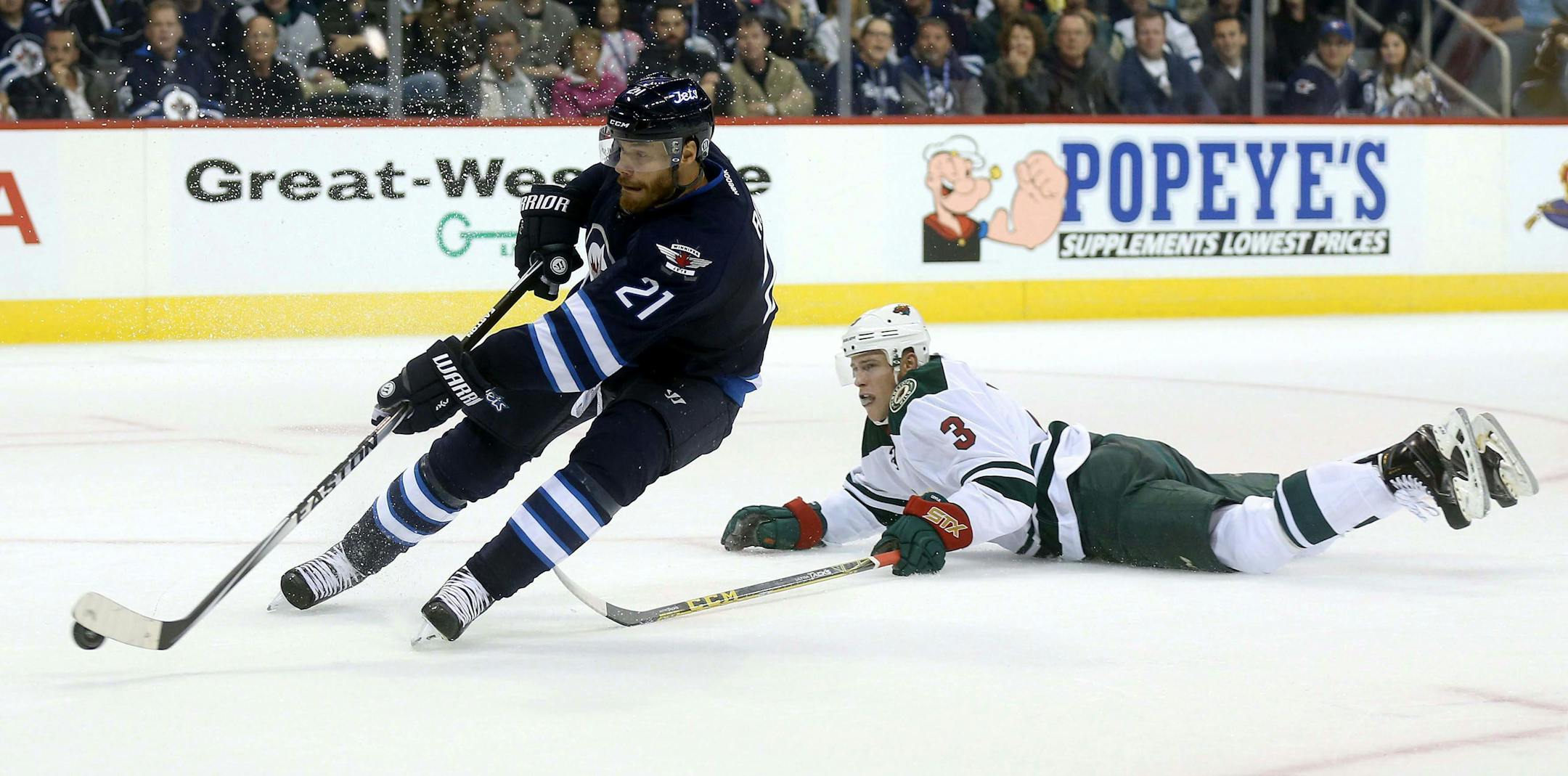 Winnipeg Jets' Thomas Raffle, left, gets past Minnesota Wild's Charlie Coyle during the second period of an NHL preseason hockey game Tuesday, Sept. 22, 2015, in Winnipeg, Manitoba. (Trevor Hagan/The Canadian Press via AP) MANDATORY CREDIT
