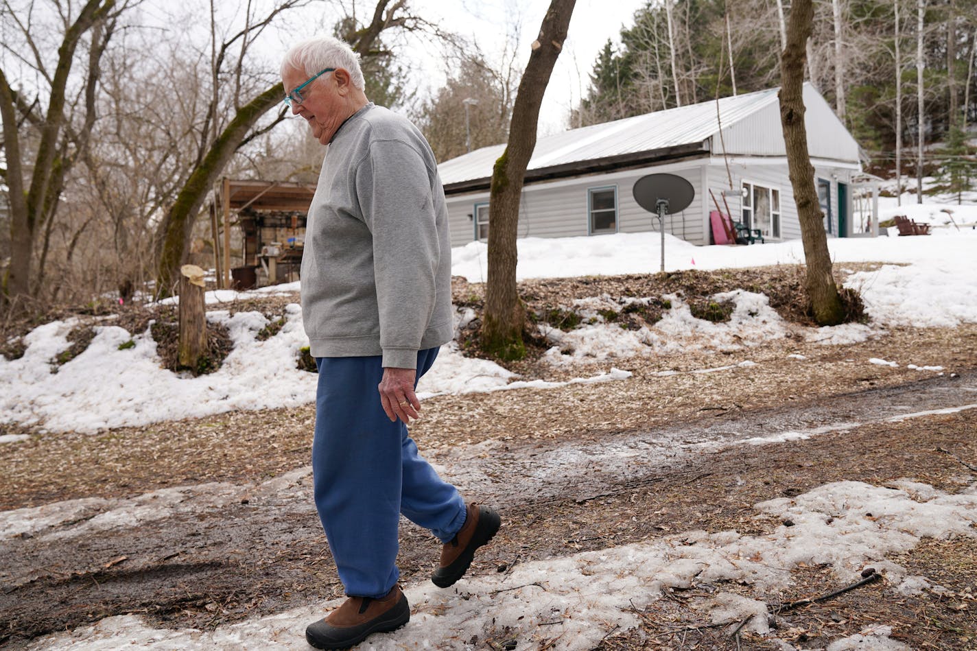 Mel Jacobson, an 85-year-old from Minnetonka who retreated to his remote cabin across the St. Croix River to wait out the Coronavirus pandemic, took a walk around his property. ] ANTHONY SOUFFLE &#x2022; anthony.souffle@startribune.com Mel Jacobson, an 85-year-old from Minnetonka who retreated to his remote cabin across the St. Croix River to wait out the Coronavirus pandemic, took a walk around his property with neighbors Tuesday, March 24, 2020 in Clear Lake, Wis.