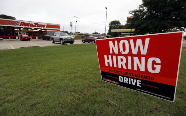 FILE- In this Sept. 27, 2018, file photo a bilingual help wanted sign for Auto Zone is posted outside the store in Canton, Miss. Against the backdrop 