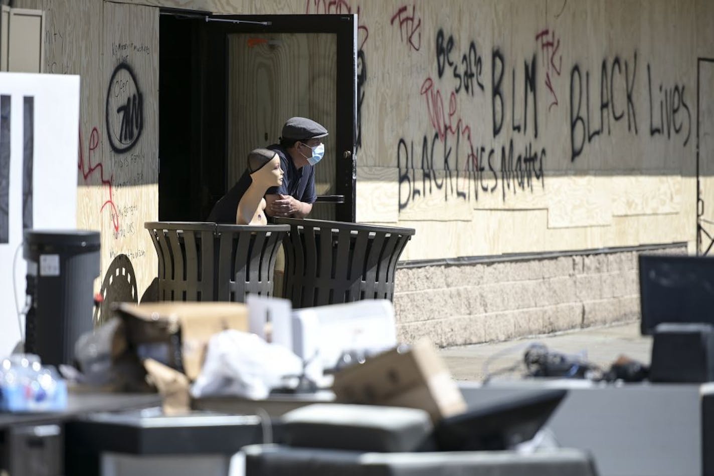 A man, who didn't wish to be identified, stood watch outside his friend's laundromat Saturday afternoon off Nicollet near the fifth precinct in an area targeted heavily by looters Friday night and early Saturday morning.