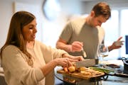 Samantha Maroney and Tyson Fulton work on preparing dinner Thursday, April 14, 2022 in Spring Lake Park, Minn. They connected right before the pandemi