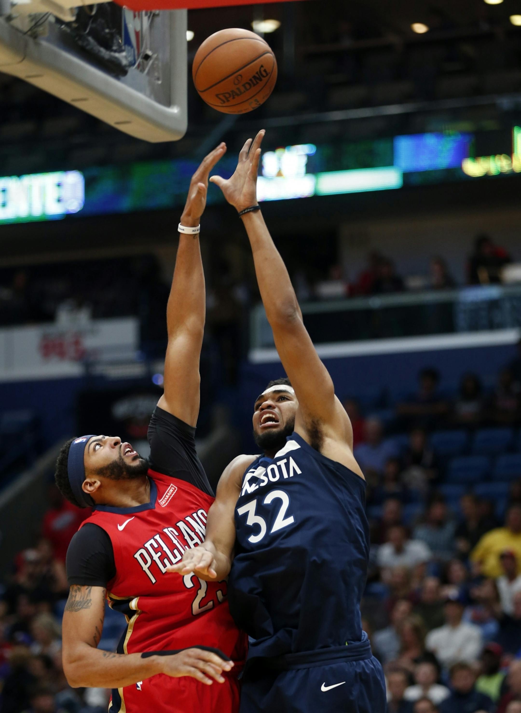 Minnesota Timberwolves center Karl-Anthony Towns (32) goes to the basket against New Orleans Pelicans forward Anthony Davis during the first half of an NBA basketball game in New Orleans, Wednesday, Nov. 29, 2017.