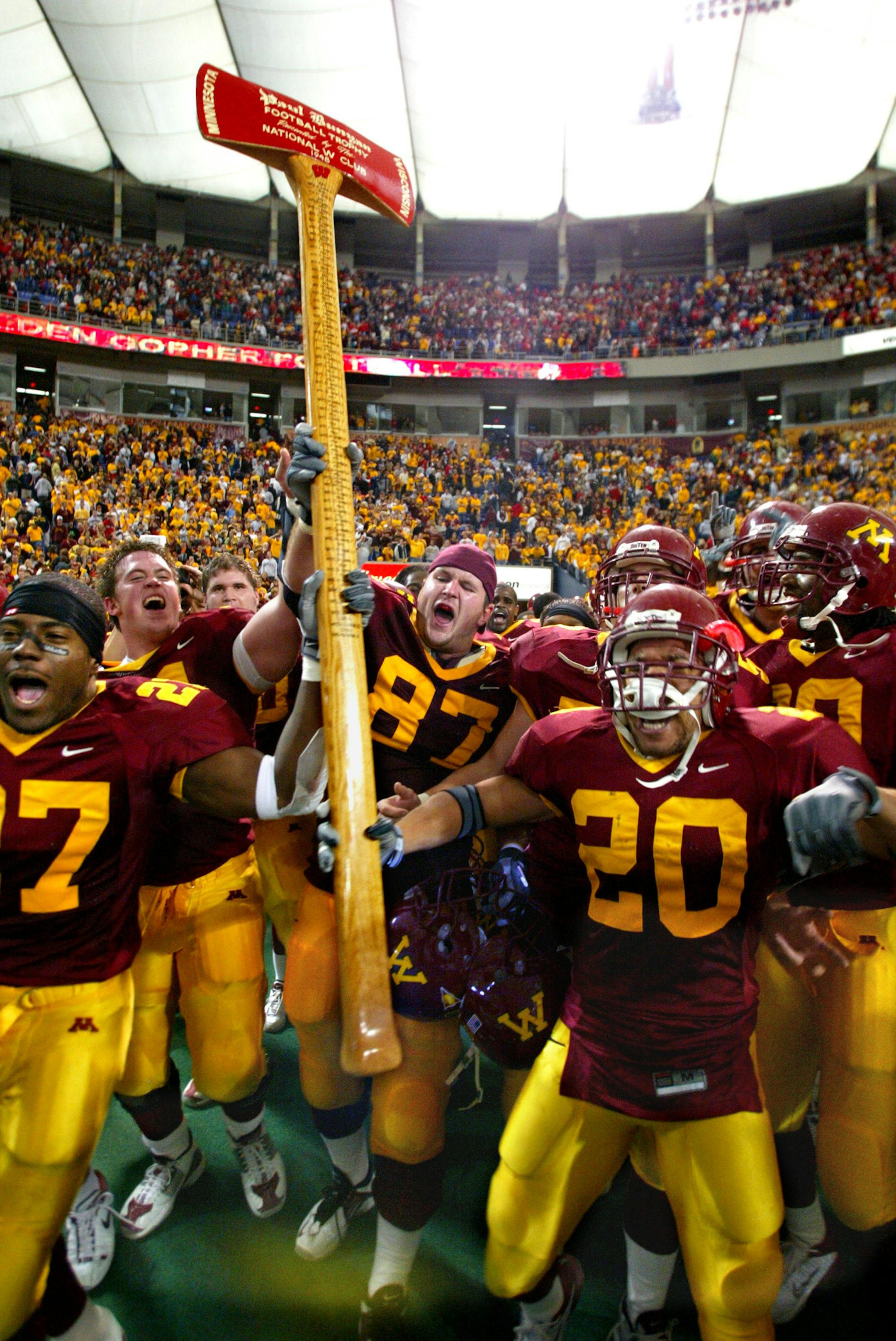 11/08/03 - Gopher football vs. Wisconsin - Minnesota wins 37-34. IN THIS PHOTO: Members of the Gopher football team lift high the Paul Bunyan axe that will be heading back to the Minnesota trophy case after they defeated Wisconsin on a last second field goal. ORG XMIT: MIN2013041713385505