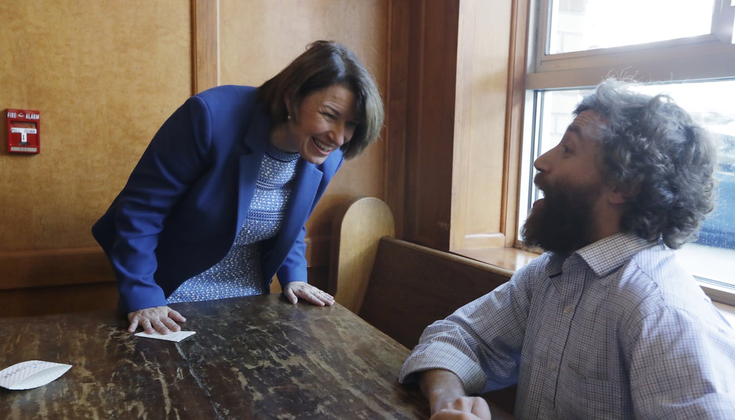 Democratic presidential candidate Sen. Amy Klobuchar, D-Minn., left, laughs as she shares a fundraising story with Seattle Times reporter David Gutman following a campaign event at a coffee house Monday, Sept. 30, 2019, in Seattle. (AP Photo/Elaine Thompson)