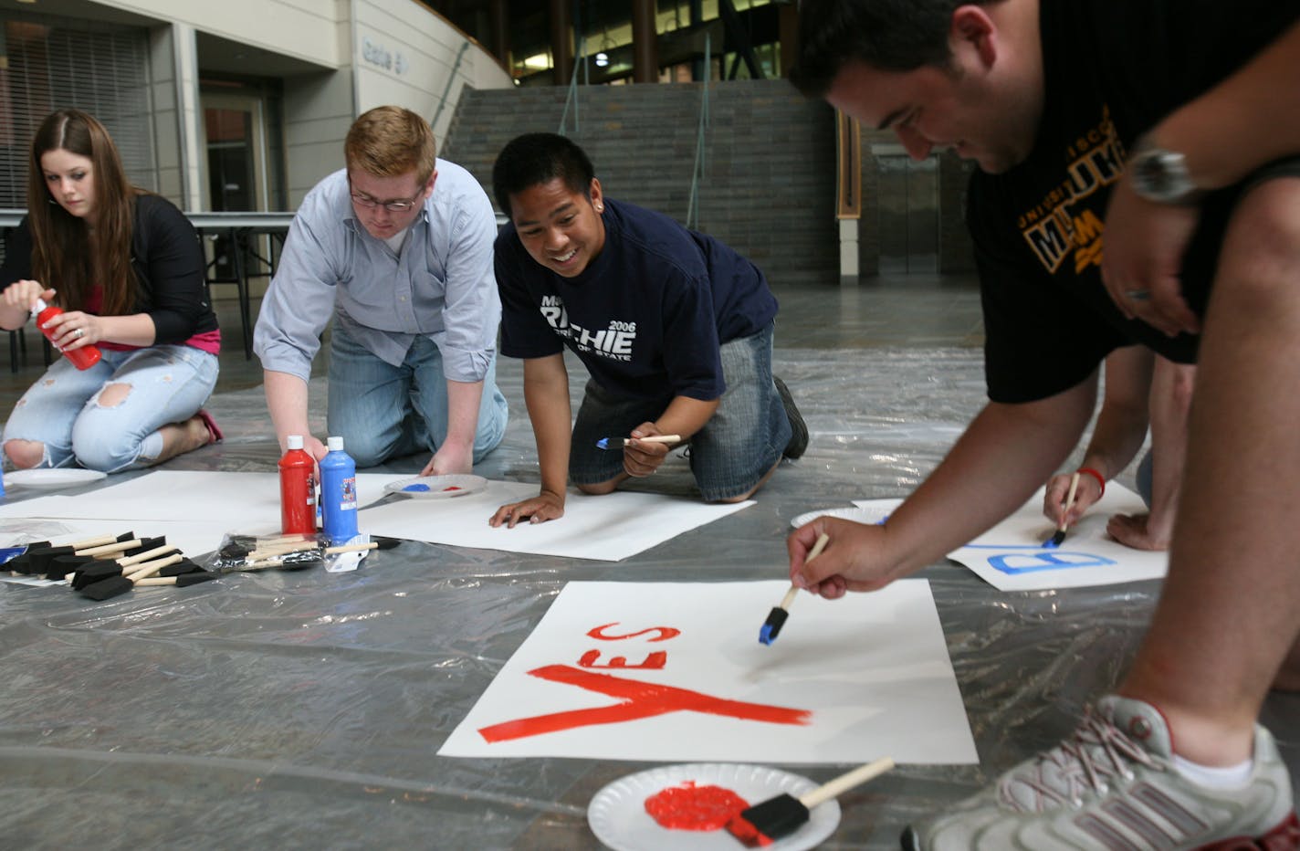 All smiles: David Gilbert-Pederson, center, and Eric Couto, right, made signs Monday in the Xcel Energy Center to greet Barack Obama on his arrival tonight.