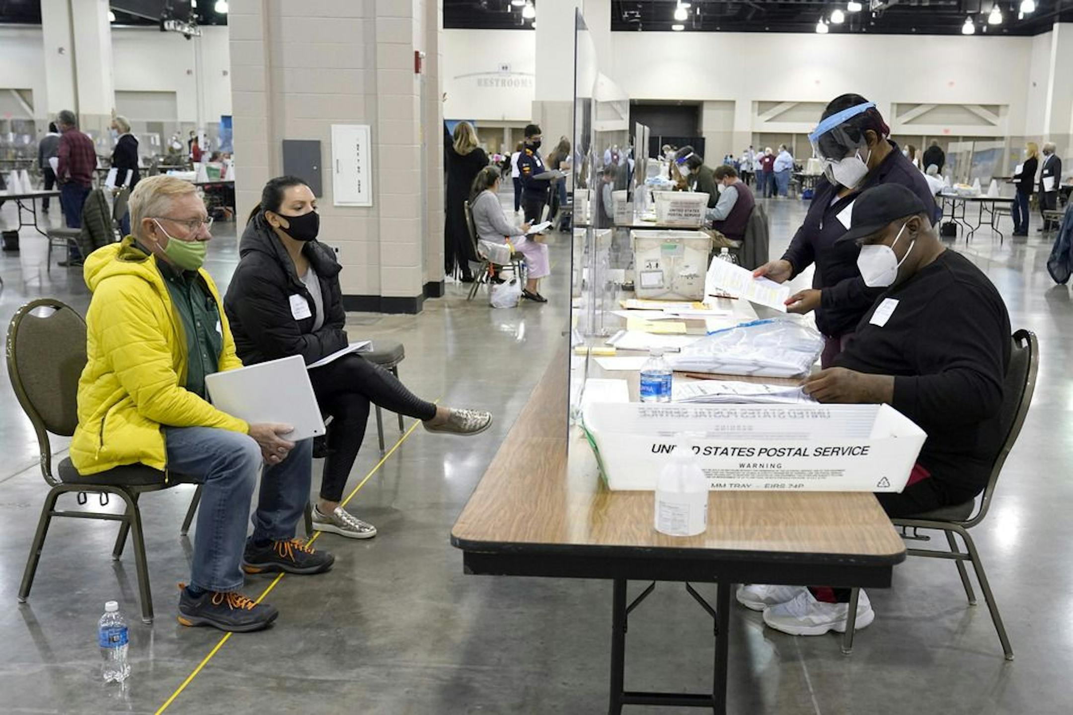 FILE - Election workers, right, verify ballots as recount observers, left, watch during a Milwaukee hand recount of presidential votes at the Wisconsin Center, Friday, Nov. 20, 2020, in Milwaukee. Wisconsin finished a partial recount of its presidential results on Sunday, Nov. 29, 2020 confirming Democrat Joe Biden's victory over President Donald Trump in the key battleground state. Trump vowed to challenge the outcome in court.