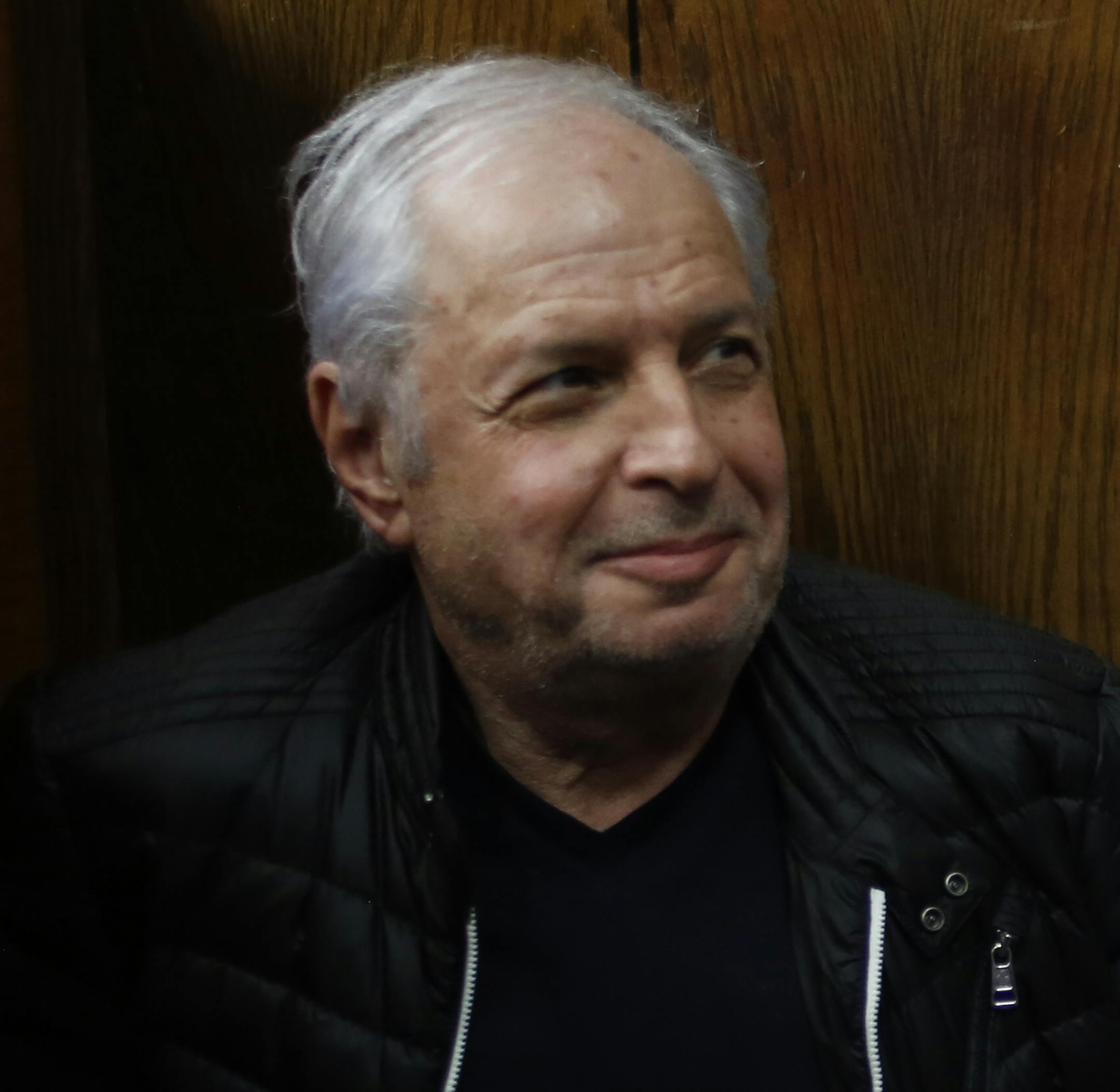 Bezeq telecom company's controlling shareholder Shaul Elovitch sits next to a policeman at the magistrate court in Tel Aviv, Israel, Thursday, Feb. 22, 2018. Elovitch is suspected of involvement in a scandal in which Israeli Prime Minister Benjamin Netanyahu promoted regulation worth hundreds of millions of dollars for Bezeq in exchange for favorable coverage in the Bezeq owned Walla News site for Netanyahu and his family,(AP Photo/Ariel Schalit) ORG XMIT: ASC108