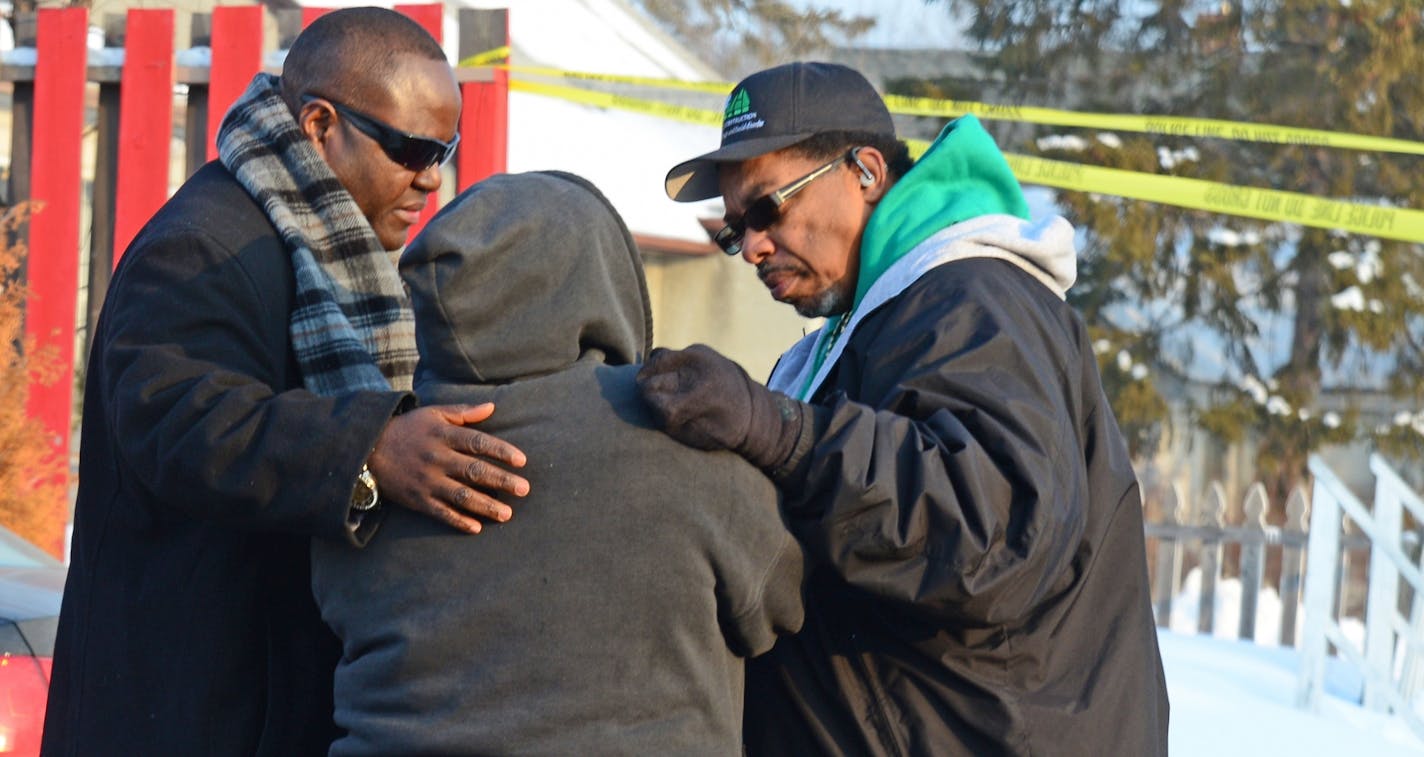 Shooting scene where two people were fatally shot and another was wounded early Friday at an after-hours establishment at 39th St. and Fremont Av. N. in Minneapolis. Monique White just learned that her step son was shot to death. She was comforted at the shooting scene by Harding Smith on the right and V.J. Smith of Mad Dads.