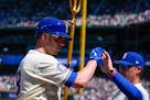 Mariners designated hitter Mitch Garver, left, holds a trident while greeting manager Scott Servais, right, after hitting a two-run homer against the 