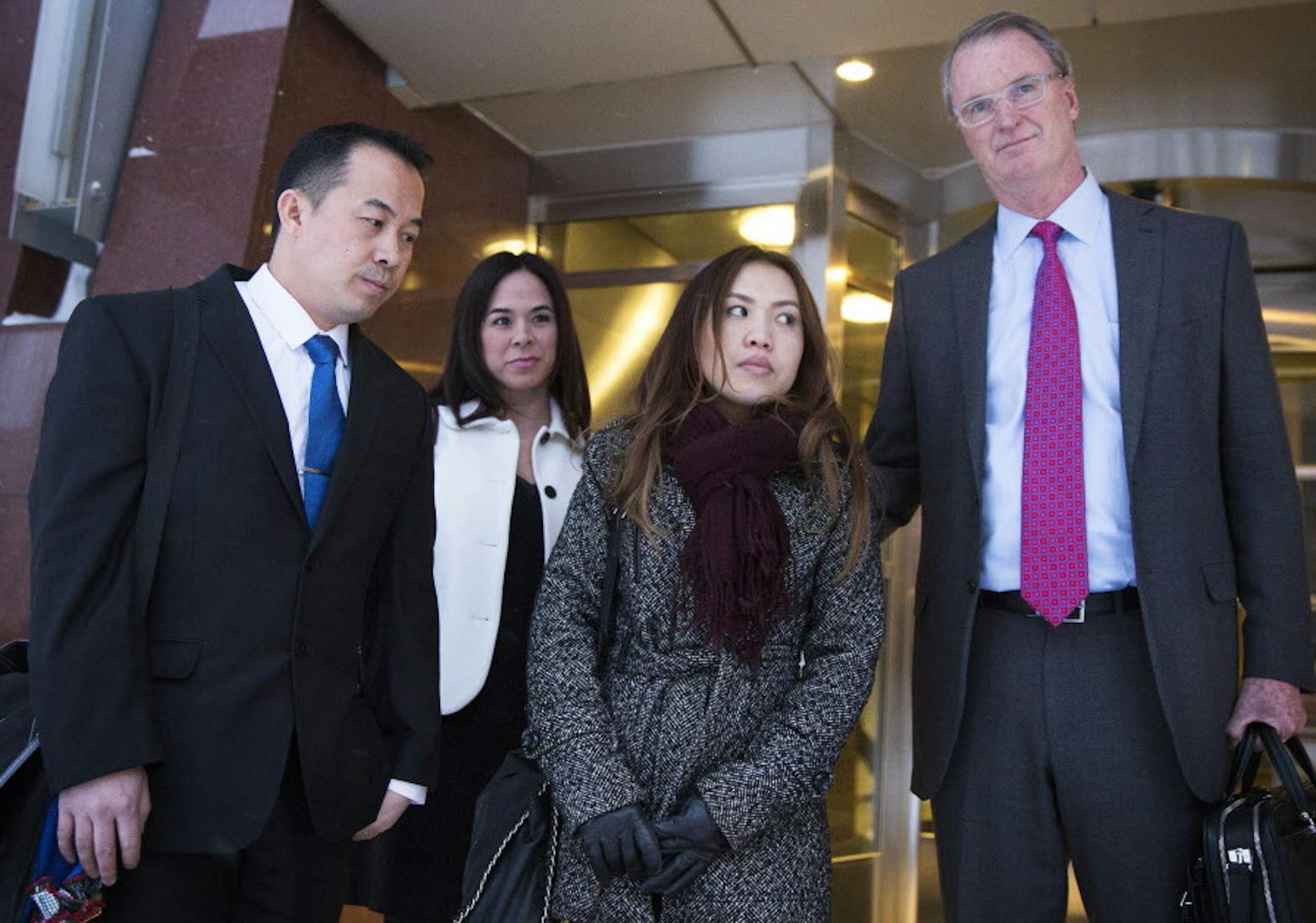 Koua Fong Lee, left, his wife Panghoua Moua and their attorney Bob Hilliard, with attorney Catherine Tobin, second from left in back, pause outside of the Federal Courthouse in Minneapolis on Thursday, January 8, 2015.