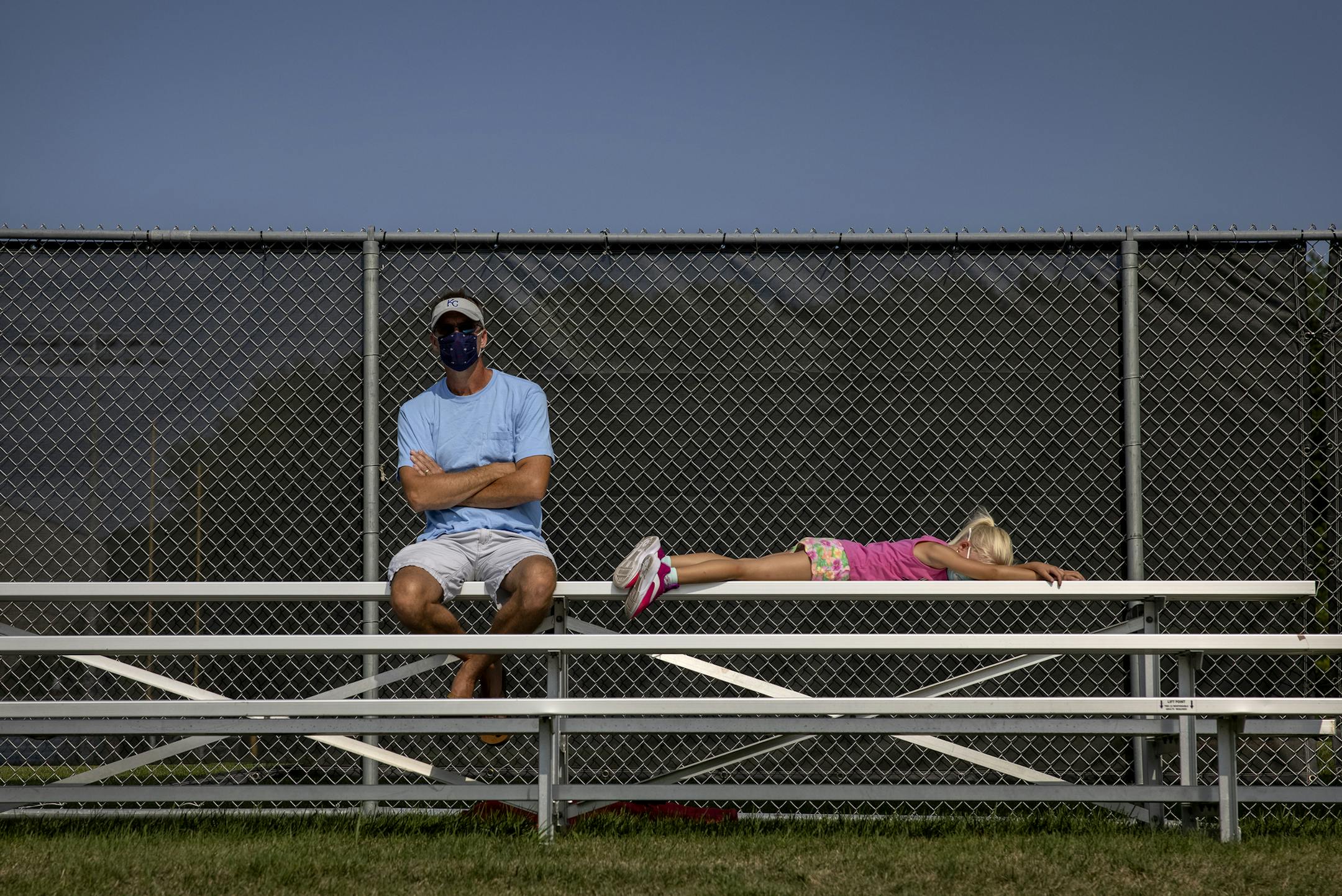 Andrew Werner and his daughter Lola, 5, watched Blake and Minnetonka girl's tennis match from the social distantly marked bleachers. Werner teaches at Minnetonka High School. ] CARLOS GONZALEZ ¥ cgonzalez@startribune.com Ð Minnetonka, MN Ð August 25, 2020, Blake at Minnetonka Girl's Tennis, two pretty good teams playing early in the season. what's different/same for playing in the age of COVID.