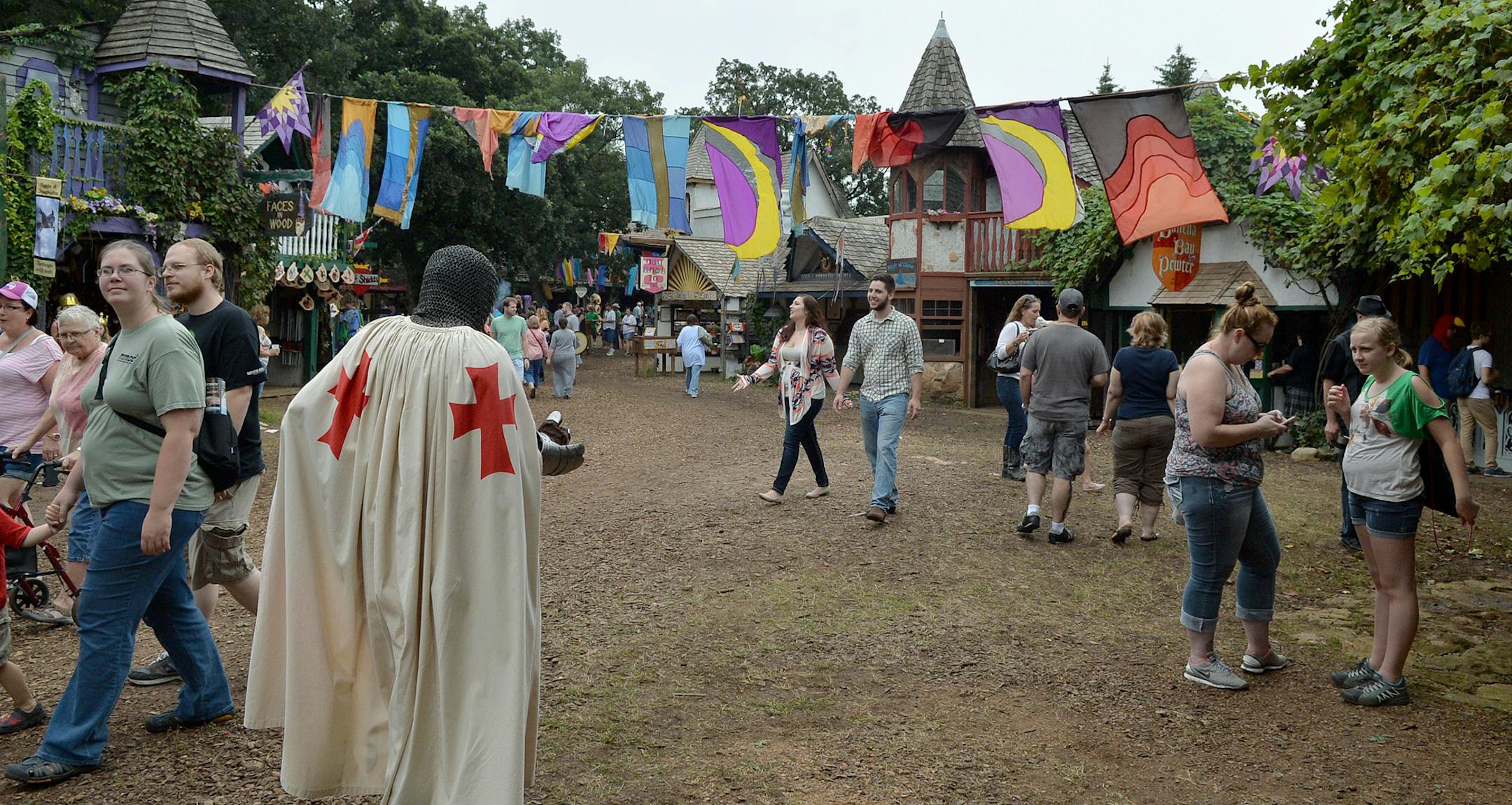 Multicolored flags drape from the eaves of roofs over the dirt streets inside the Minnesota Renaissance Festival. ] (SPECIAL TO THE STAR TRIBUNE/BRE McGEE)