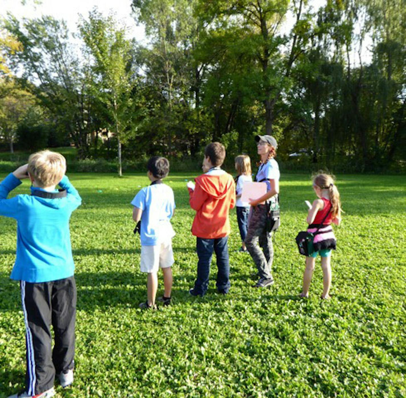 2. Amy Simso Dean (in hat) and some of her bird-watching crew scan the school property for new species. credit: Val Cunningham, special to the Star Tribune