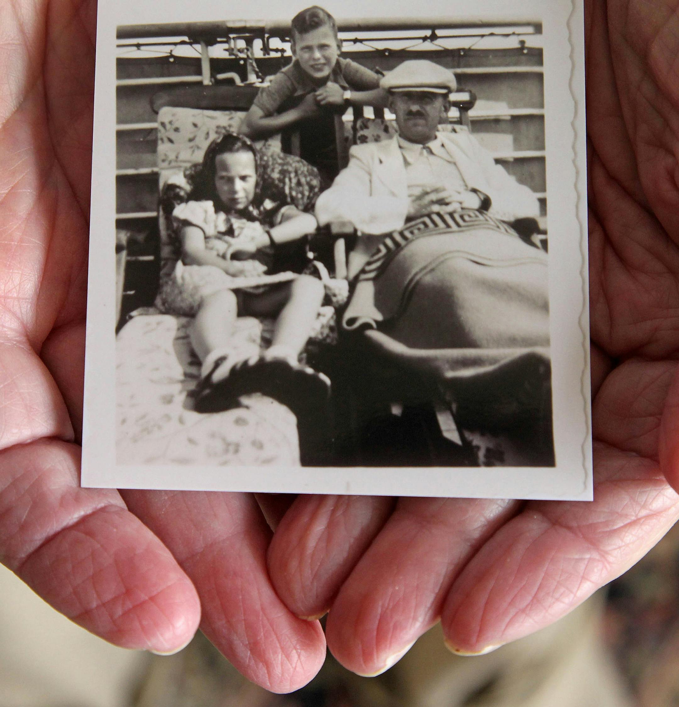 Herbert Karliner, one of the survivors of the 900 Jewish refugees fleeing Hitler who were turned away from Miami when they arrived aboard the ocean liner, St. Louis, in 1939, shares photos and documents from his ordeal on Nov. 18, 2015 in Aventura, Fla. Karliner places in his hand a photo of his sister, Ruth, 11, left, himself, 12, and his father, Joseph Karliner on the St. Louis. (Carl Juste/Miami Herald/TNS)