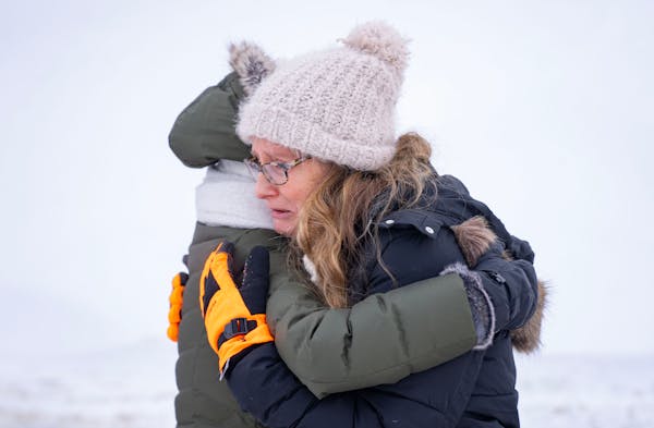 Nancy Musser embraces her daughter-in-law, Julia Musser, as they searched for Nancy’s son, George Musser, Sunday in Stillwater.