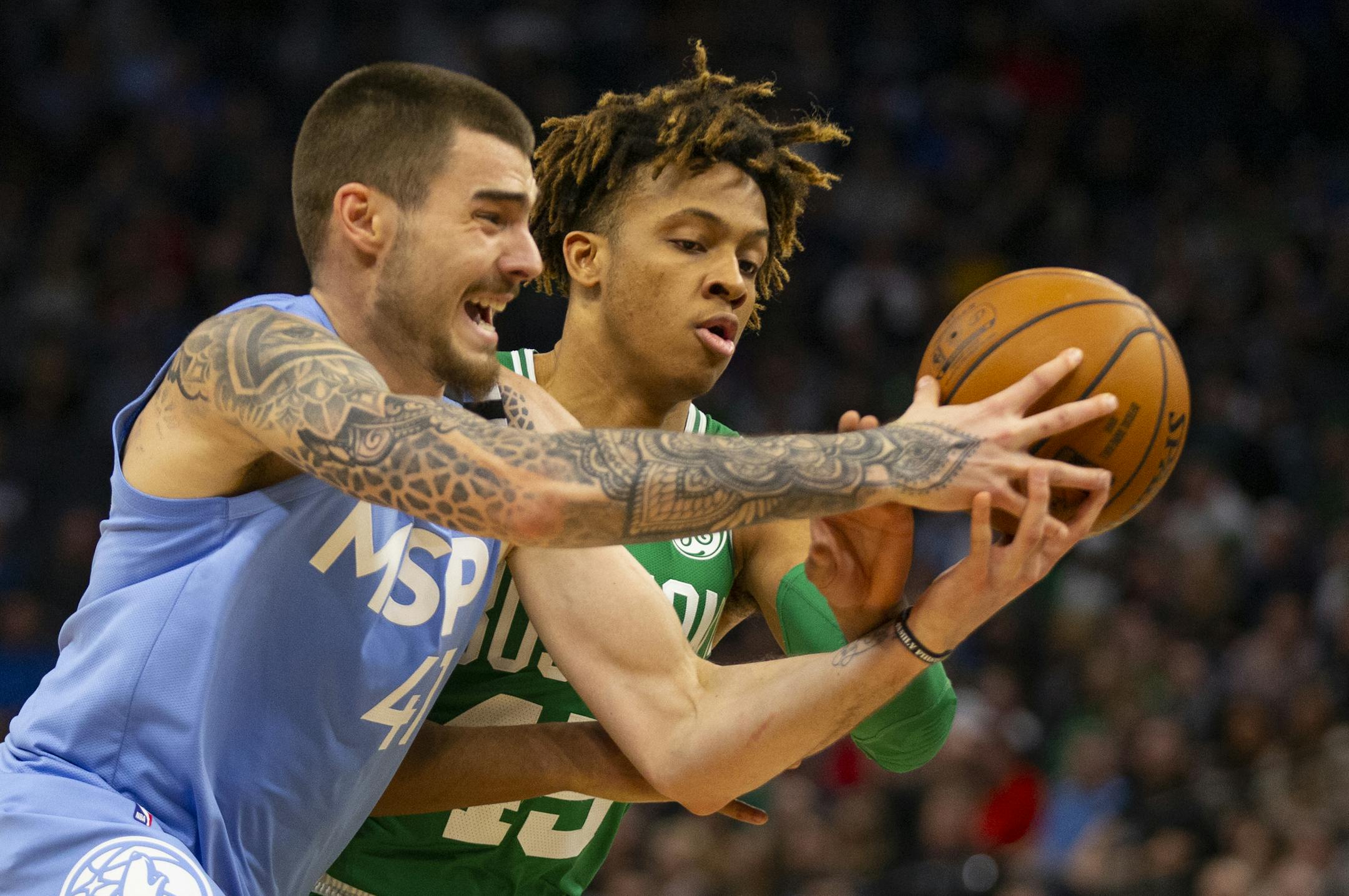 Boston Celtics forward Romero Langford (45) and Minnesota Timberwolves forward Juancho Hernangomez (41) battle for the ball in the fourth quarter of an NBA basketball game Friday, Feb. 21, 2020, in Minneapolis. (AP Photo/Andy Clayton-King)