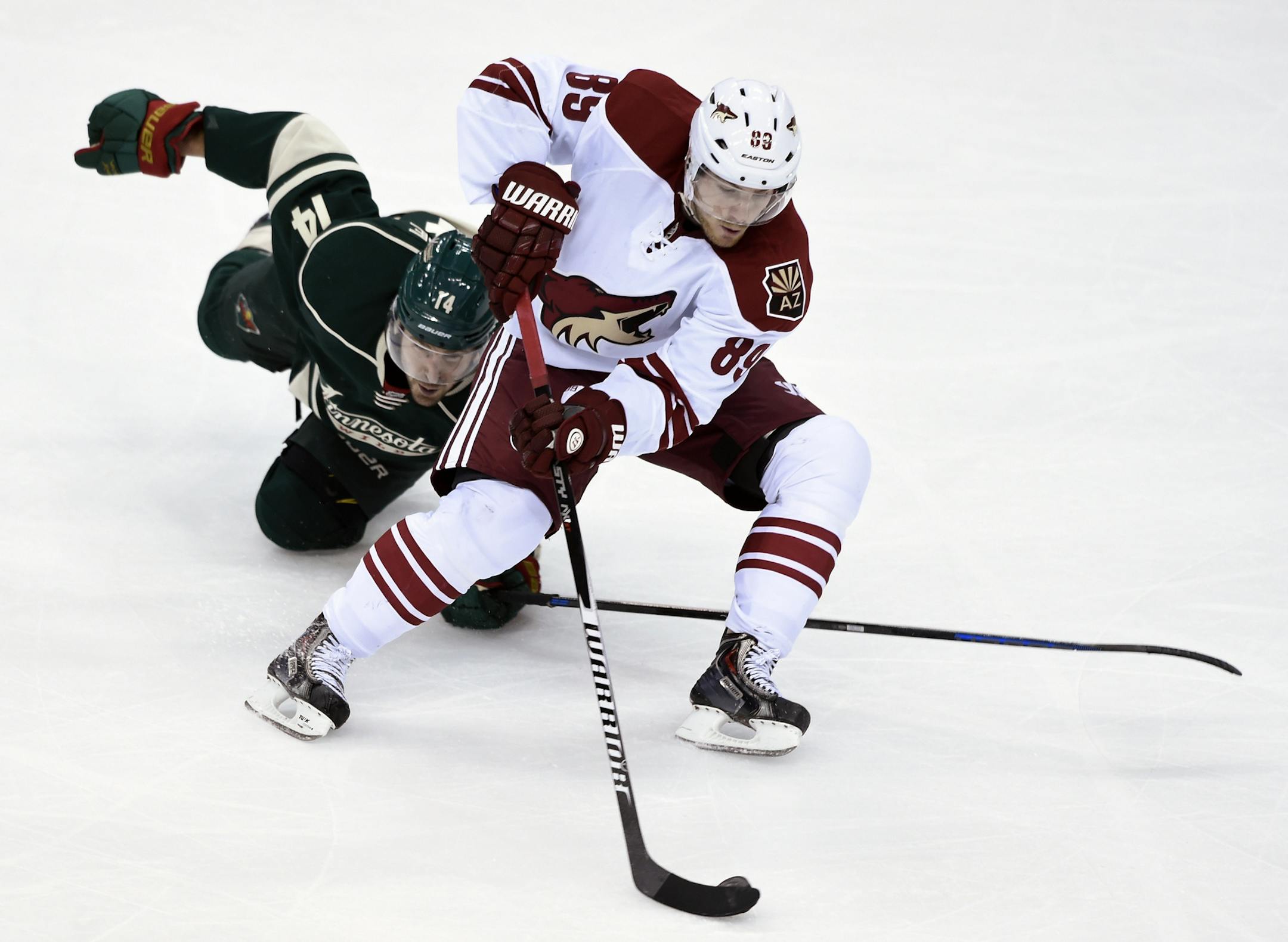 Arizona Coyotes left wing Mikkel Boedker (89), of Denmark, keeps the puck away from Minnesota Wild right wing Justin Fontaine (14) during the third period of an NHL hockey game Saturday, Jan. 17, 2015, in St. Paul, Minn. The Wild won 3-1. (AP Photo/Hannah Foslien)