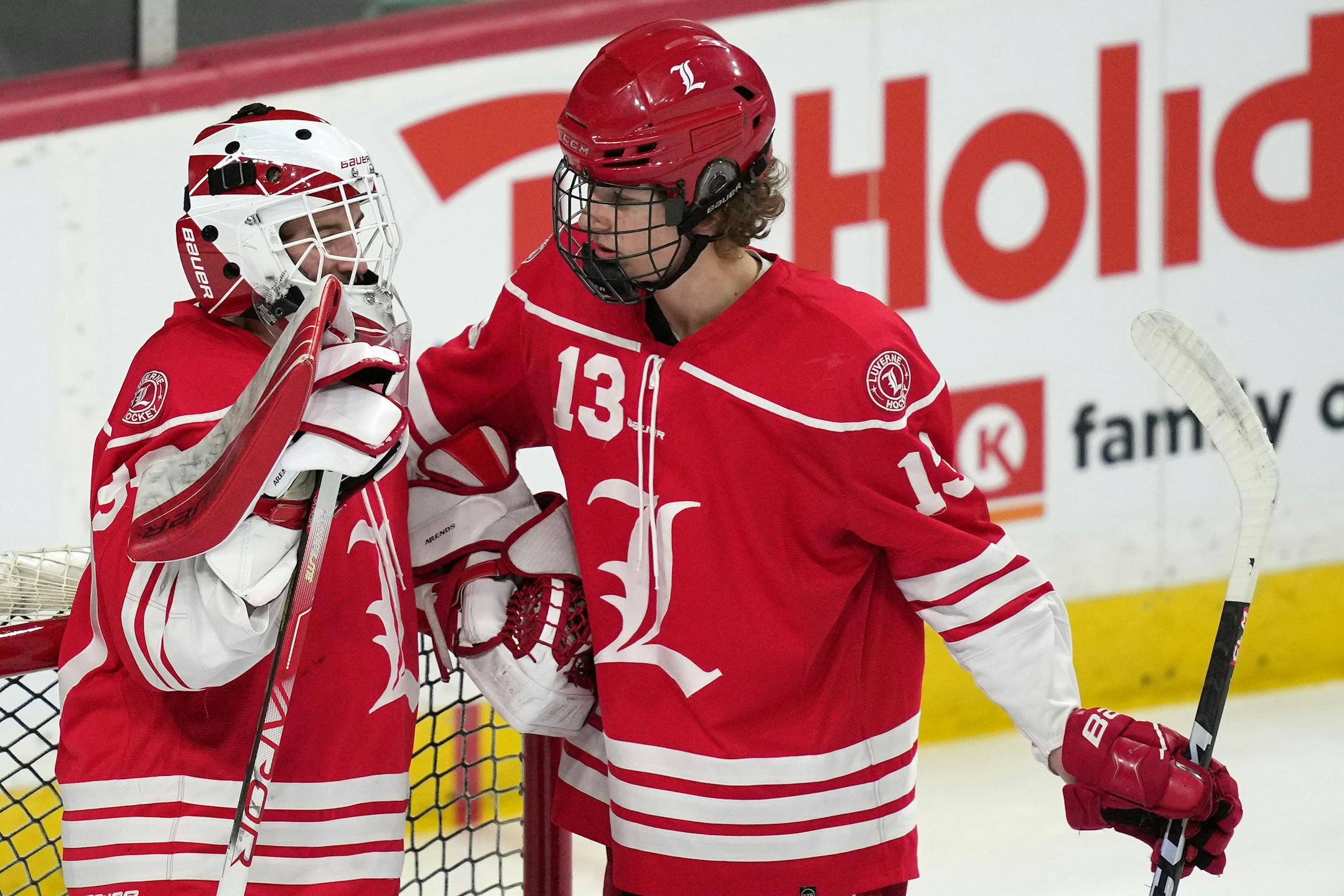 Luverne defenseman Blaik Bork (13) talks with goaltender Tyler Arends (30) after Hermantown scored three goals in the first period of a MSHSL Class 1A quarterfinal hockey game between Luverne and Hermantown.