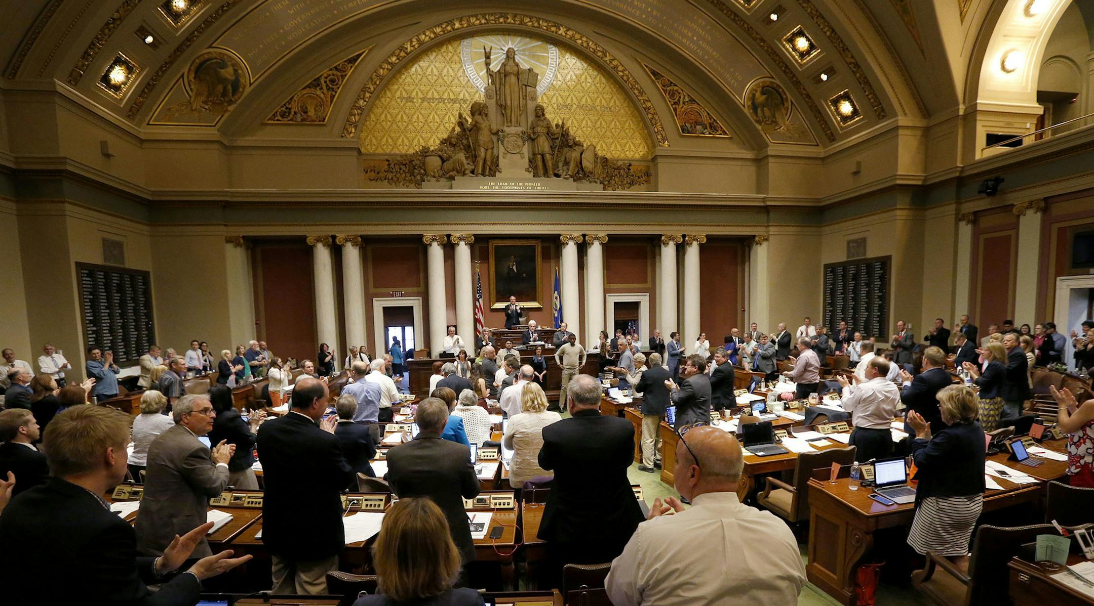 Member of the house stand and applaud on the final day of the session during recognition of veterans Sunday, May 22, 2016, in St. Paul, Minn. Minnesota's legislative session ended in chaos and with a pile of unfinished work early Monday morning. (Carlos Gonzalez/Star Tribune via AP) MANDATORY CREDIT; ST. PAUL PIONEER PRESS OUT; MAGS OUT; TWIN CITIES LOCAL TELEVISION OUT ORG XMIT: MIN2016052312401508