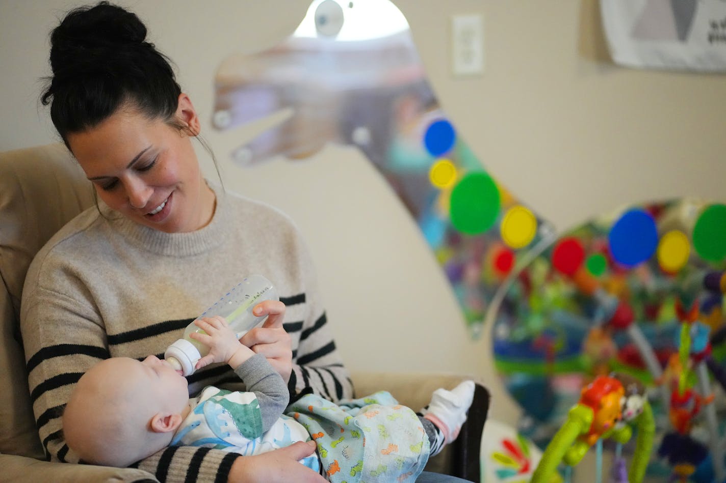 Director Katie Mitrovich gave 4-month-old Finn Gustafson a bottle on Dec. 13 at Iron Range Tykes Learning Center in Mountain Iron, Minn.