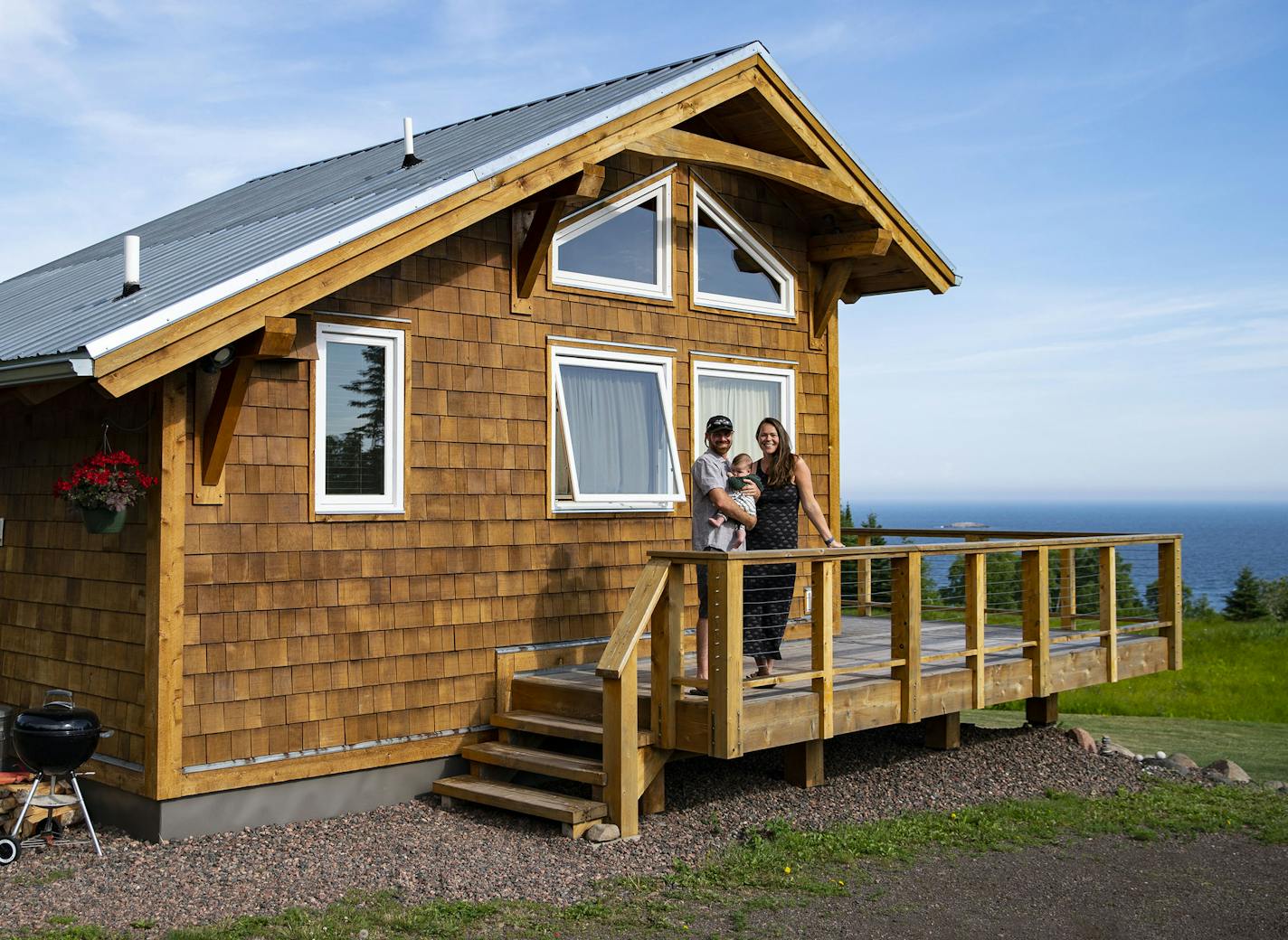 Andrew and Simone Strand held their 4-month-old son Eddie in front of their cabin in Grand Marais that they rent out as an Airbnb.