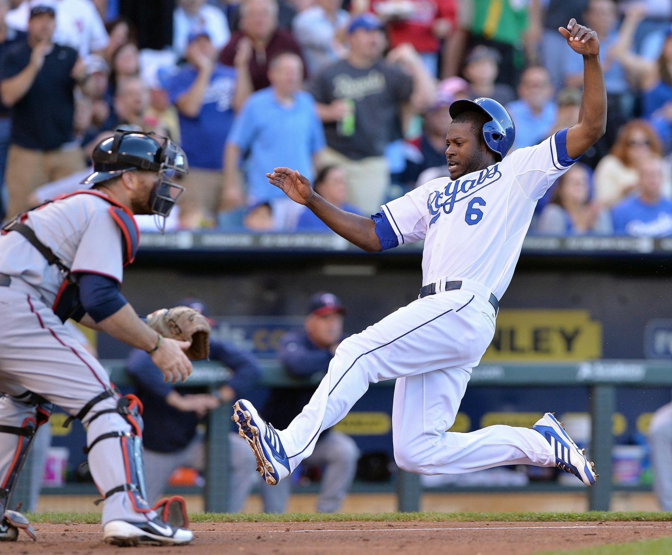 Kansas City Royals' Lorenzo Cain scores before the tag from Twins catcher Ryan Doumit on a two-run single by Chris Getz in the second inning on June 6, 2013, at Kauffman Stadium