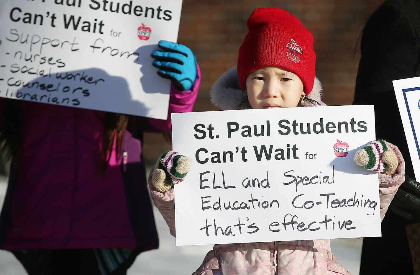 Gaoshiaxa Cha, 7, cq, stood alongside her mother Maysy Ly-Lo, cq, an ELL Education Assistant, to support the St. Paul teachers union as they gathered at the American Indian Magnet School for a rally, Wednesday, February 17, 2017 in St. Paul, MN.