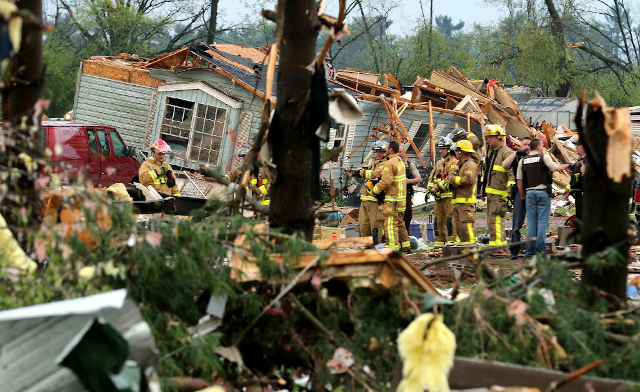 Firefighters work the site of the damage after a tornado ripped through Prairie Lake Estates trailer home park, just north of Chetek, Wis., Tuesday.