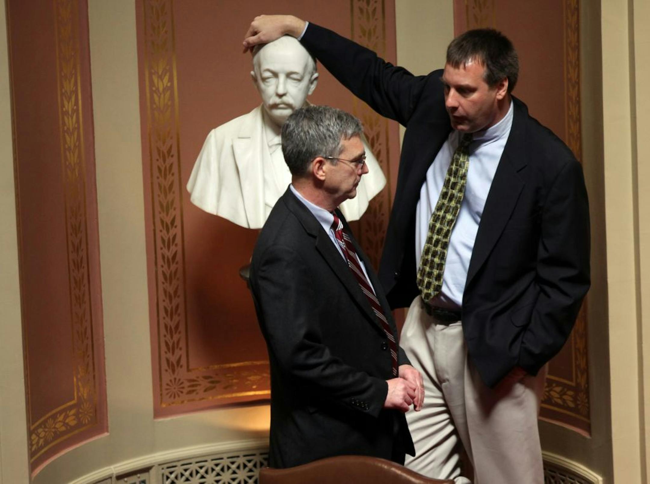 Leaning on a bust of former Gov. Cushman Davis, Republican state Sen. Chris Gerlach of Apple Valley chatted with GOP state Sen. David Hann of Eden Prairie before the start of a special session at the State Capitol in St. Paul on Tuesday.