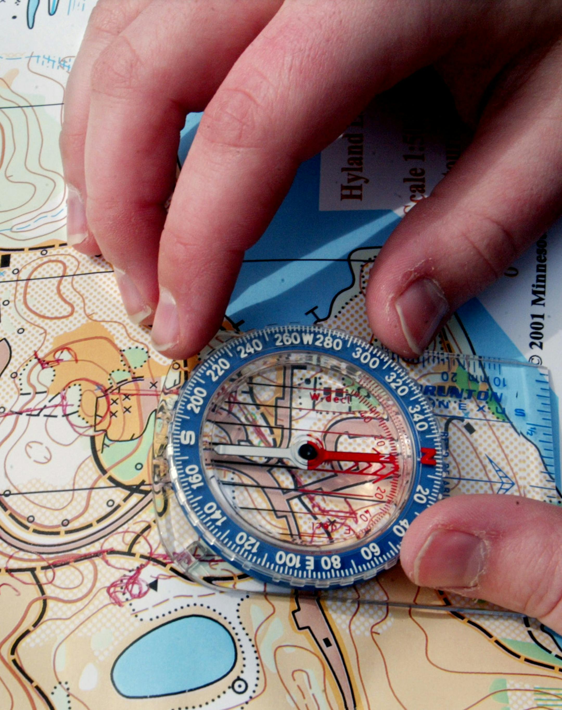 Bloomington - Hyland Park Preserve - Minnesota Orienteering Club outing at the park where indivduals and teams follow routes through the park following topographical maps using a compass in an effort to complete the course in a prescribed amount of time.
In This Photo: One orienteering participant uses his compass to find his way on the route.