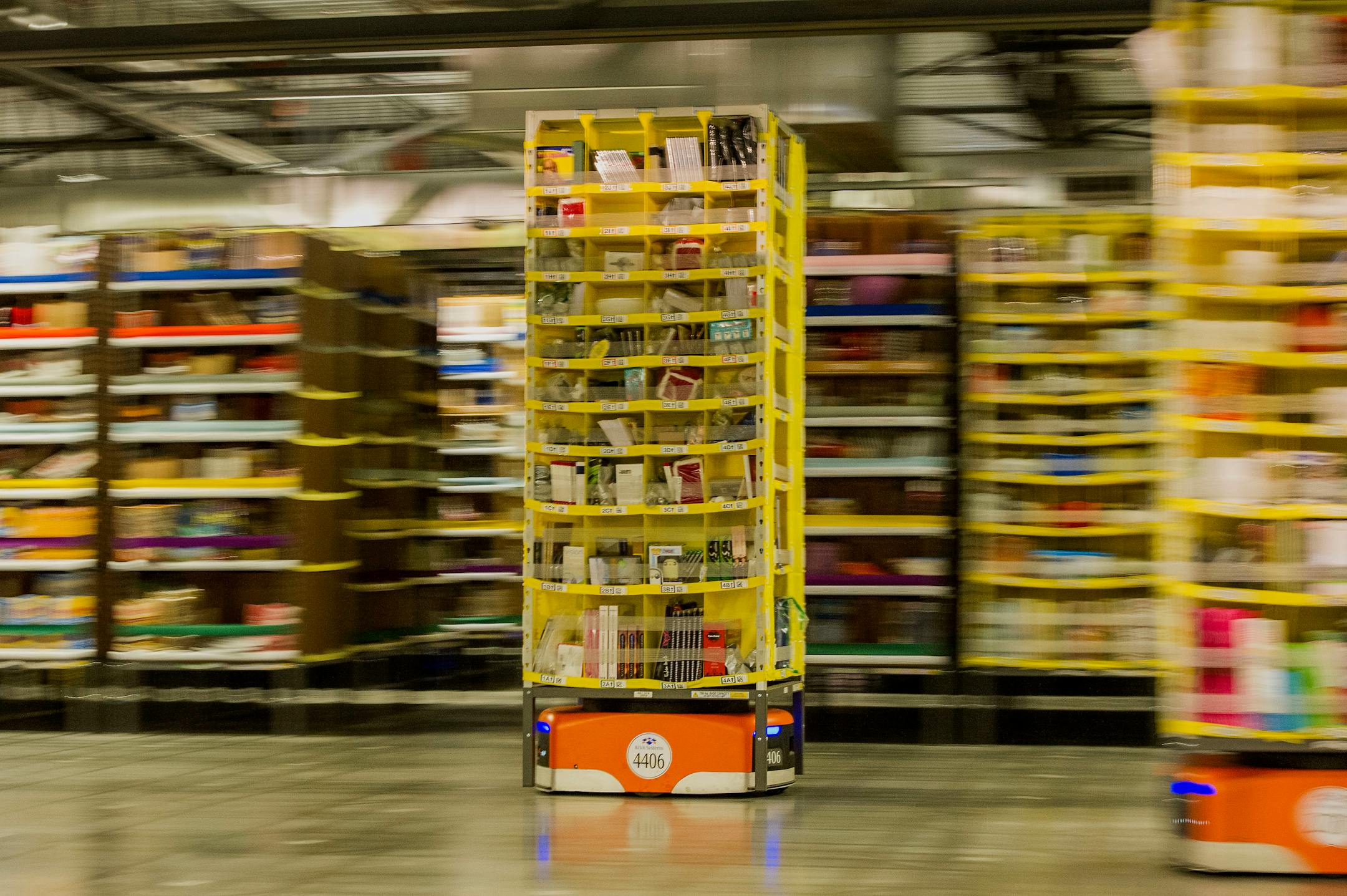 Kiva Systems LLC robots move shelves to fill orders at the Amazon.com Inc. fulfillment center on Cyber Monday in Tracy, California, U.S., on Monday, Dec. 1, 2014. Internet holiday shopping rose 8.7 percent on Cyber Monday, slowing from the same time frame last year as consumers spread their online purchases over more days. Photographer: David Paul Morris/Bloomberg