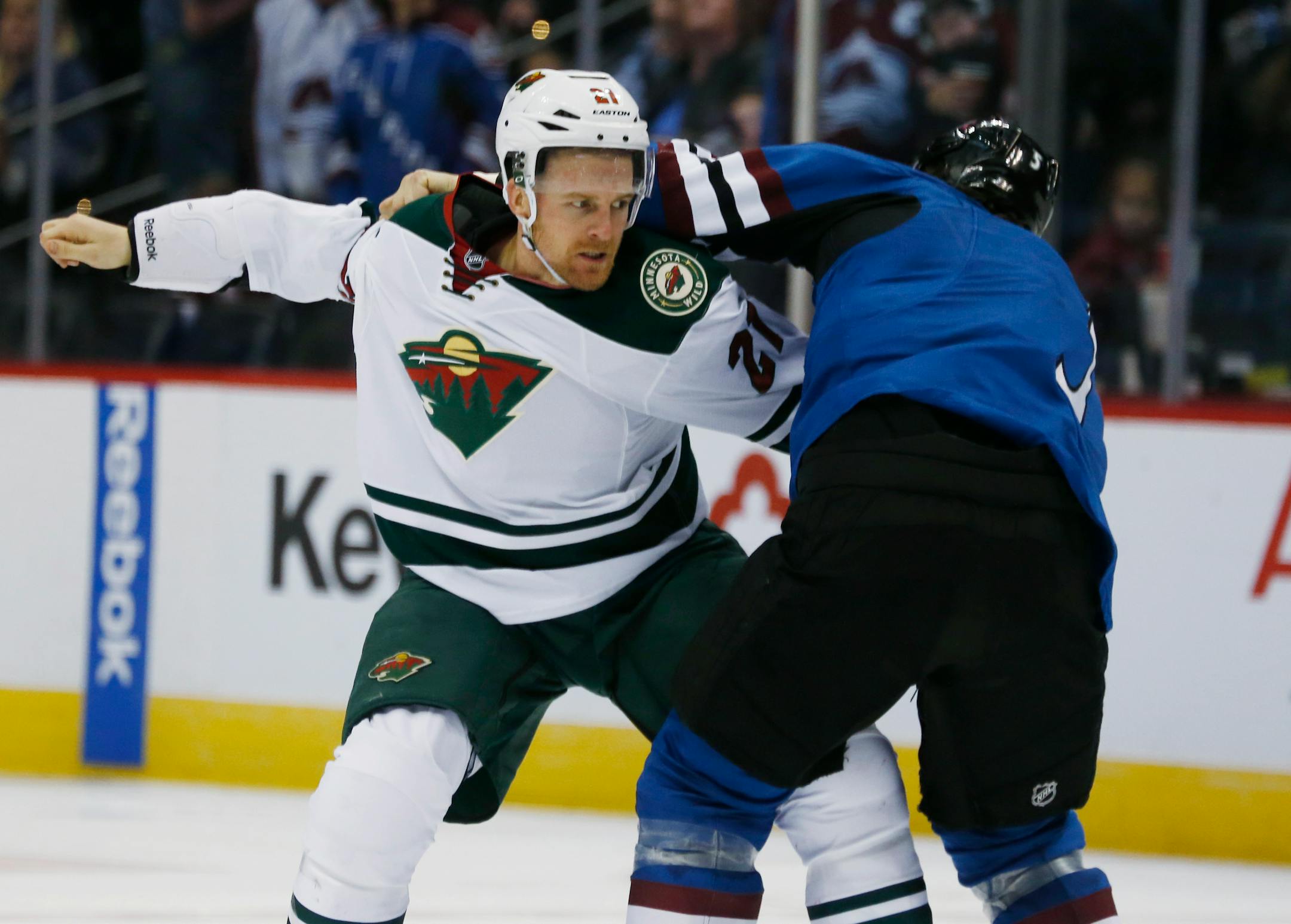 Minnesota Wild center Kyle Brodziak, left, fights with Colorado Avalanche defenseman Nate Guenin during the third period of an NHL hockey game Saturday, Feb. 28, 2015, in Denver. The Wild won 3-1. (AP Photo/David Zalubowski)