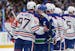 Canucks captain Quinn Hughes, front right, and Oilers captain Connor McDavid talk after the Oilers won Game 7 of their second-round playoff series Mon