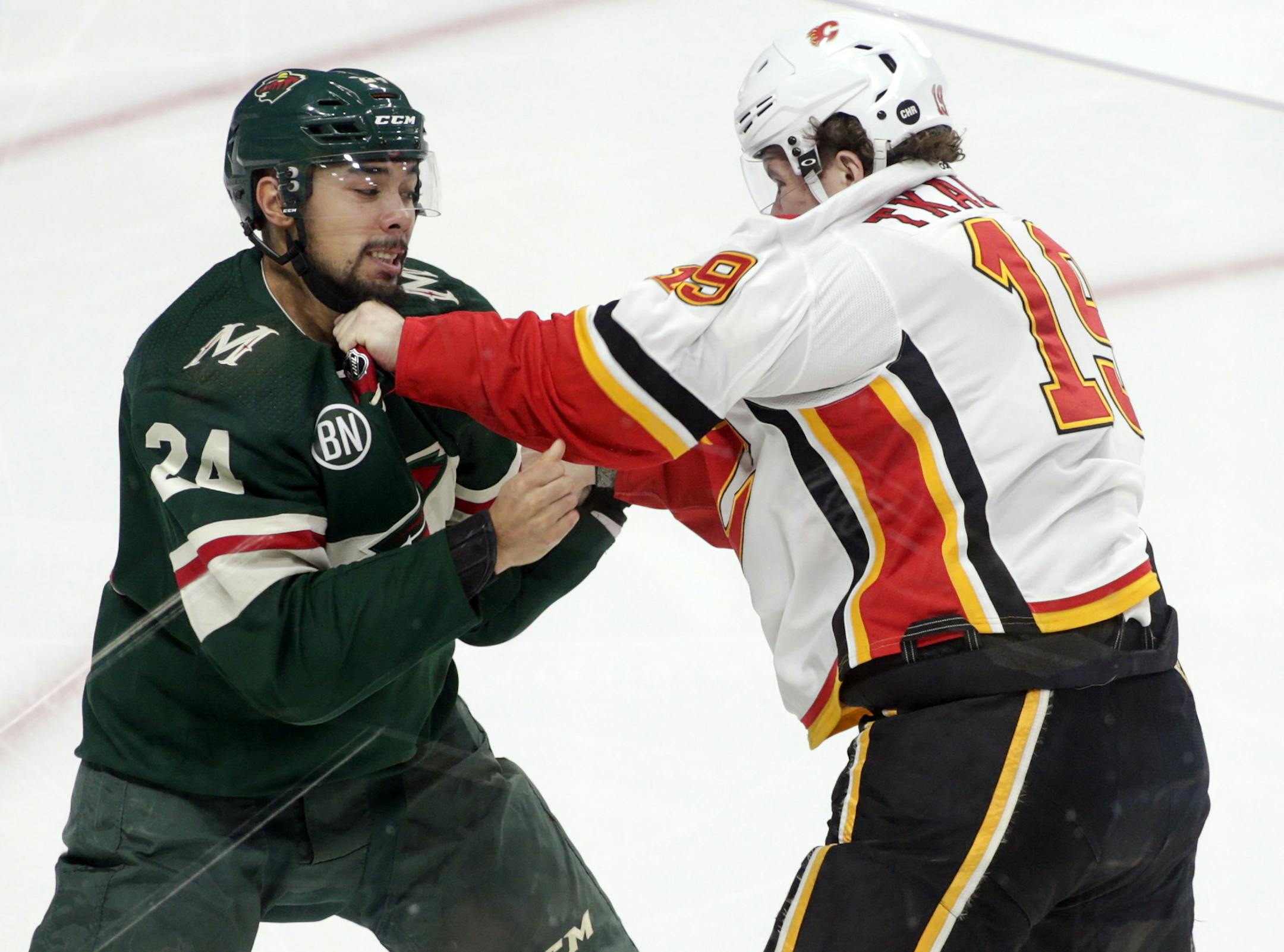 Minnesota Wild defenseman Matt Dumba (24)and Calgary Flames left wing Matthew Tkachuk (19) fight during the first period of an NHL hockey game Saturday, Dec. 15, 2018, in St. Paul, Minn. Calgary won 2-1. (AP Photo/Paul Battaglia)