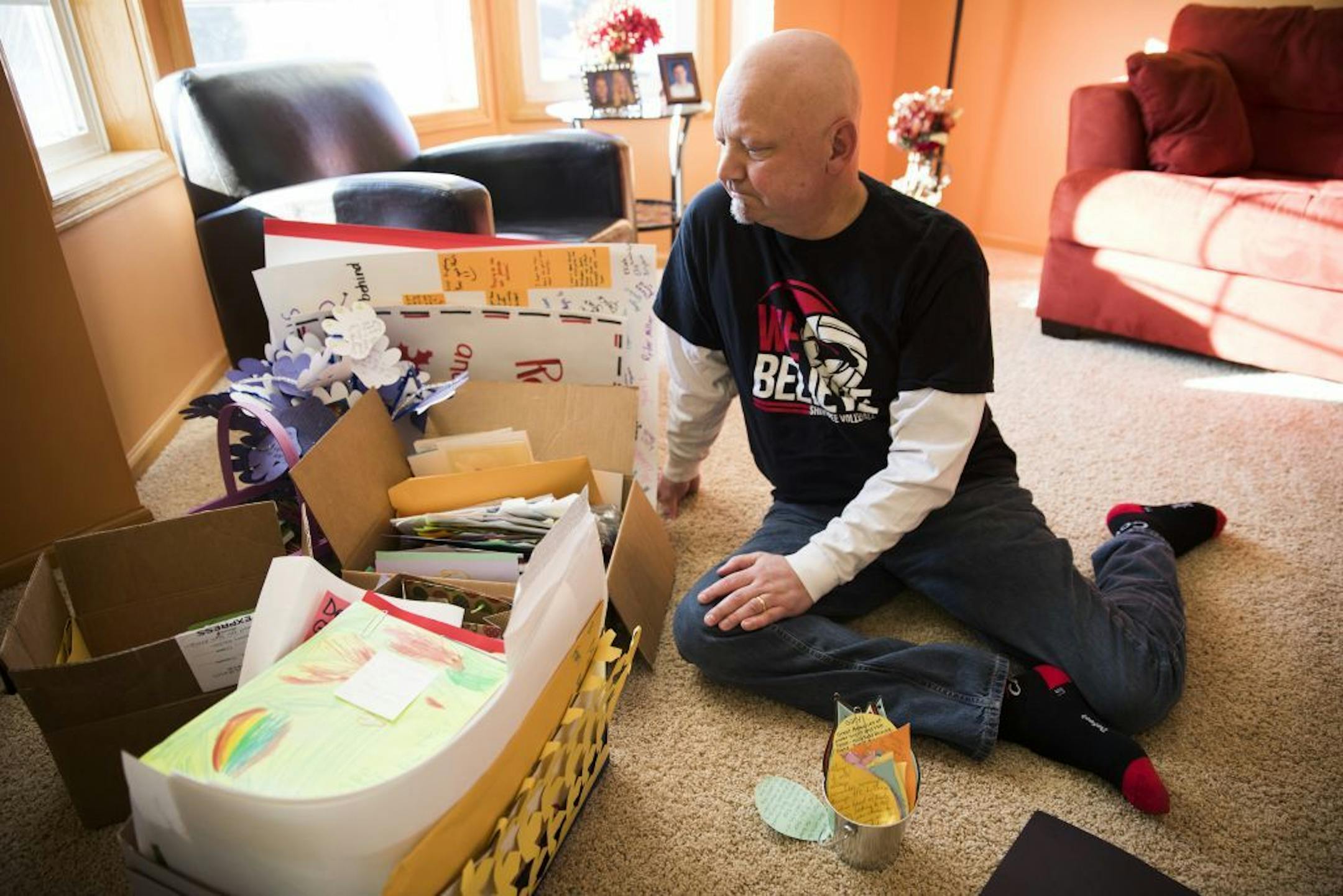 Gary Anger sits with the thousands of hand-drawn letters and cards from students, teachers and school staff that he received after his cancer diagnosis.